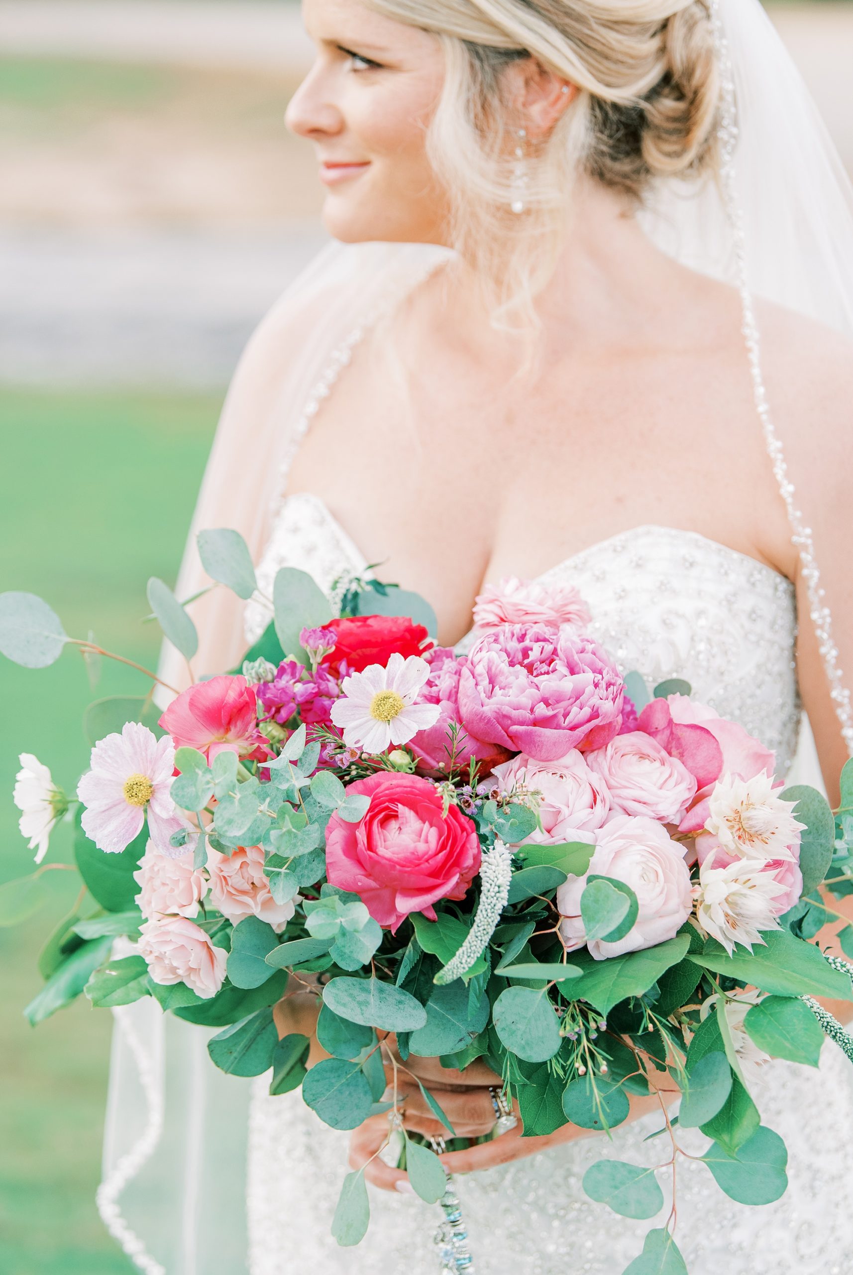 bride holds bouquet of pink peonies