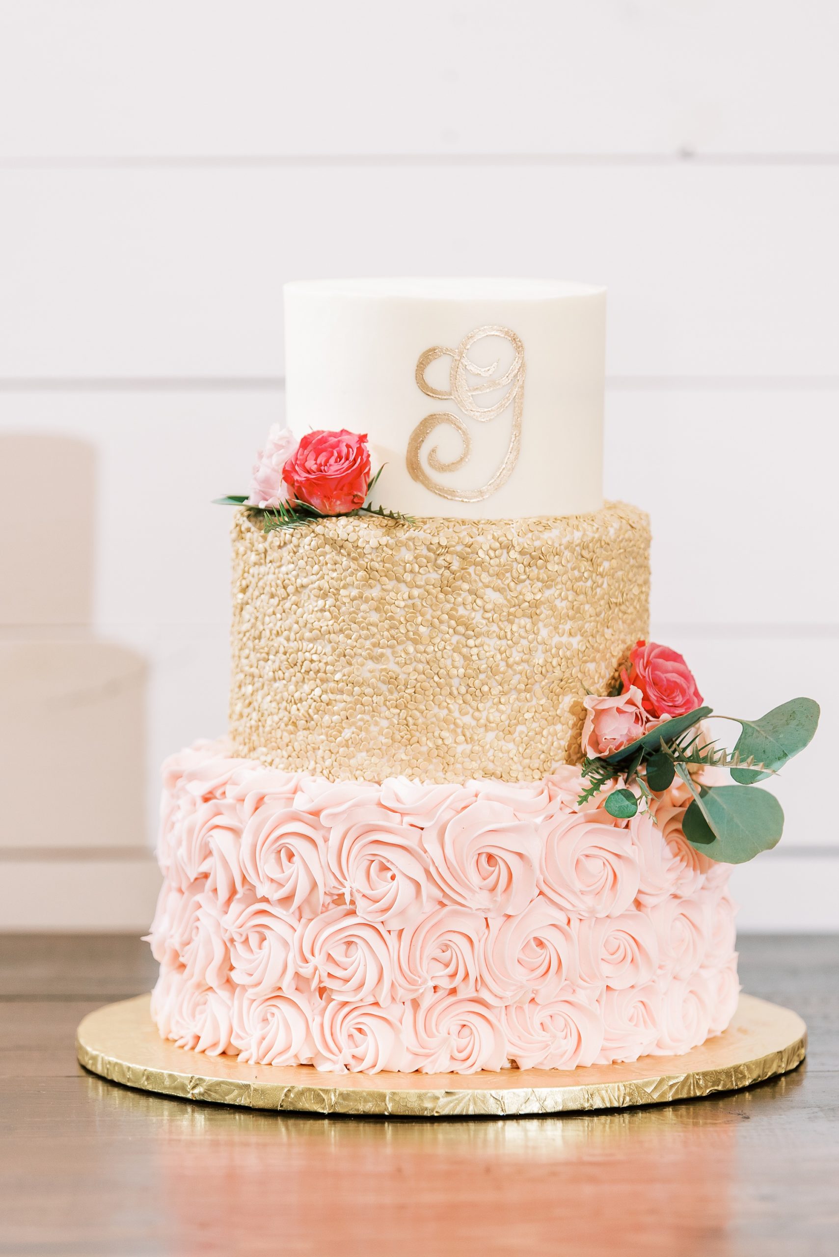 tiered wedding cake with pink and gold icing