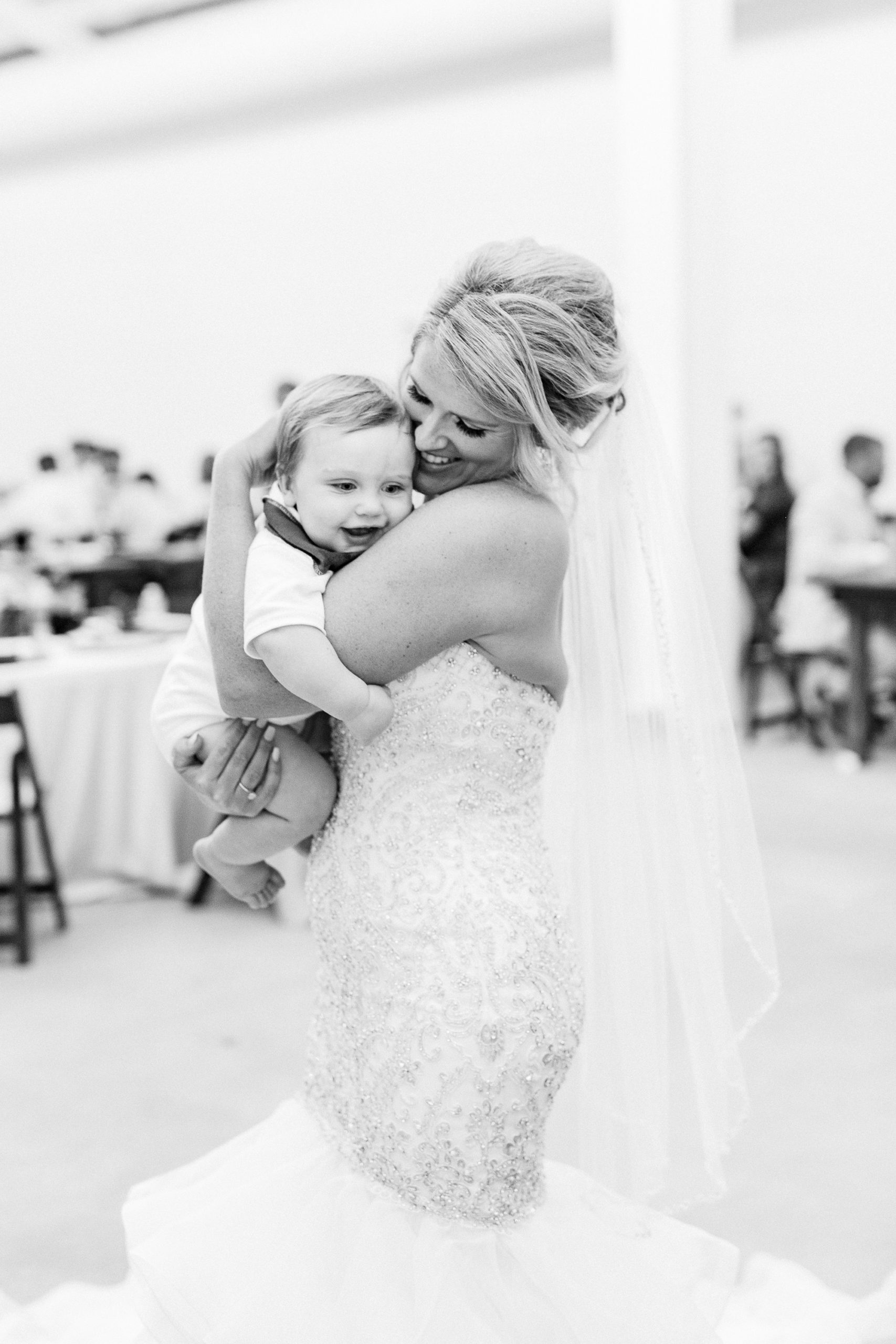 bride hugs son during wedding reception