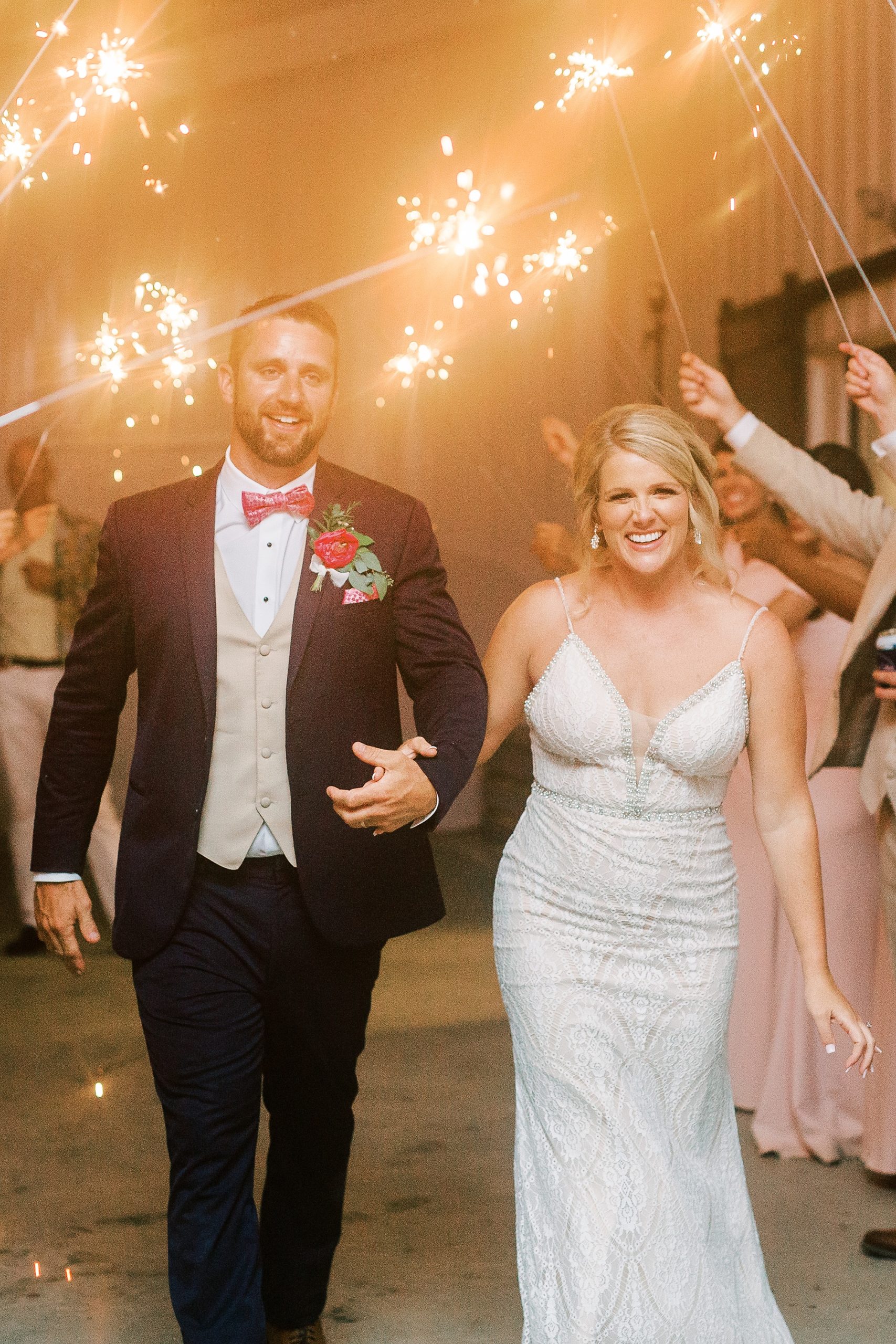 bride and groom smile during sparkler exit