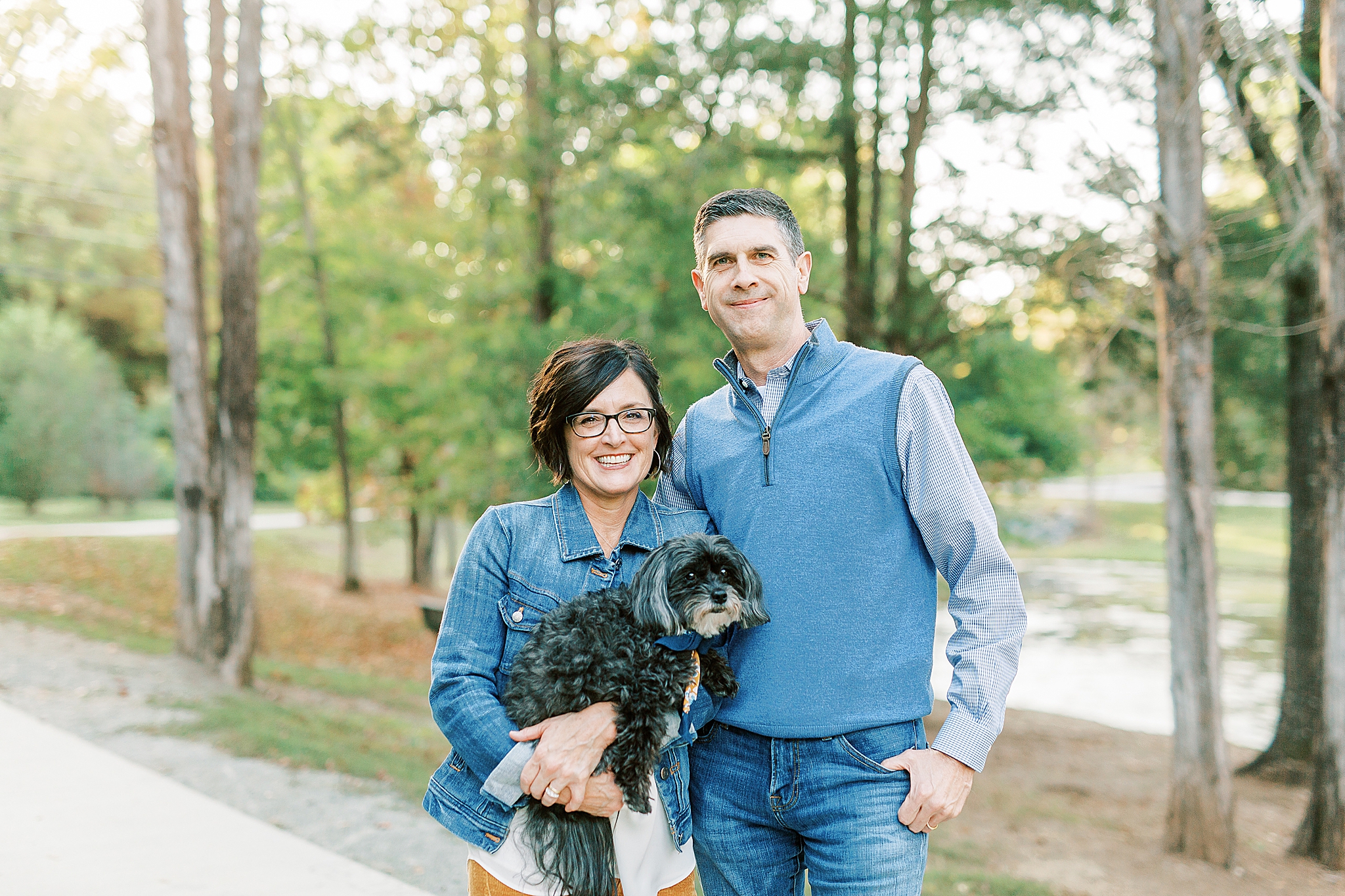 parents hold small lap dog during NC family photos