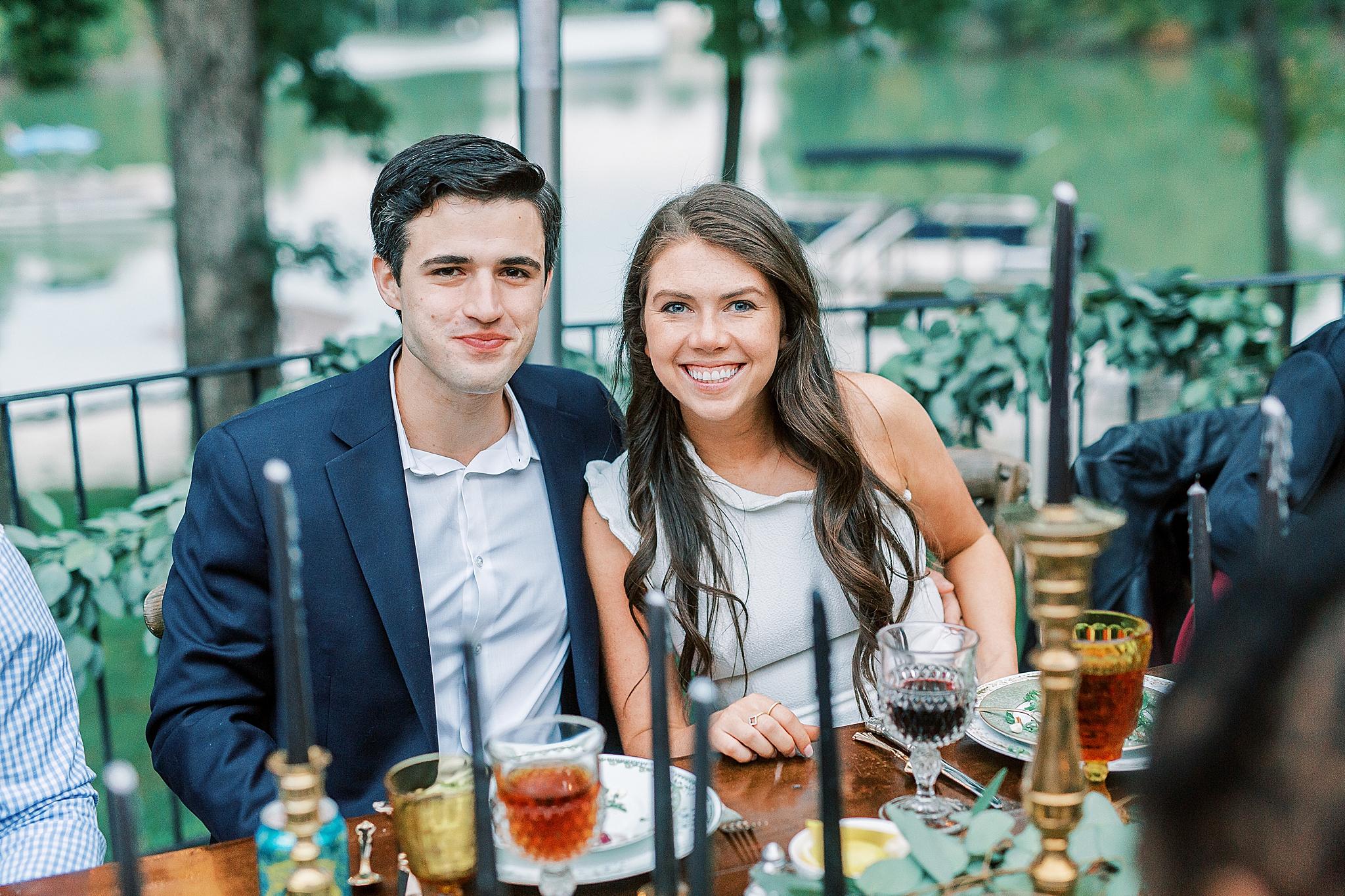 bride and groom smile at table during Charlotte NC Rehearsal Dinner