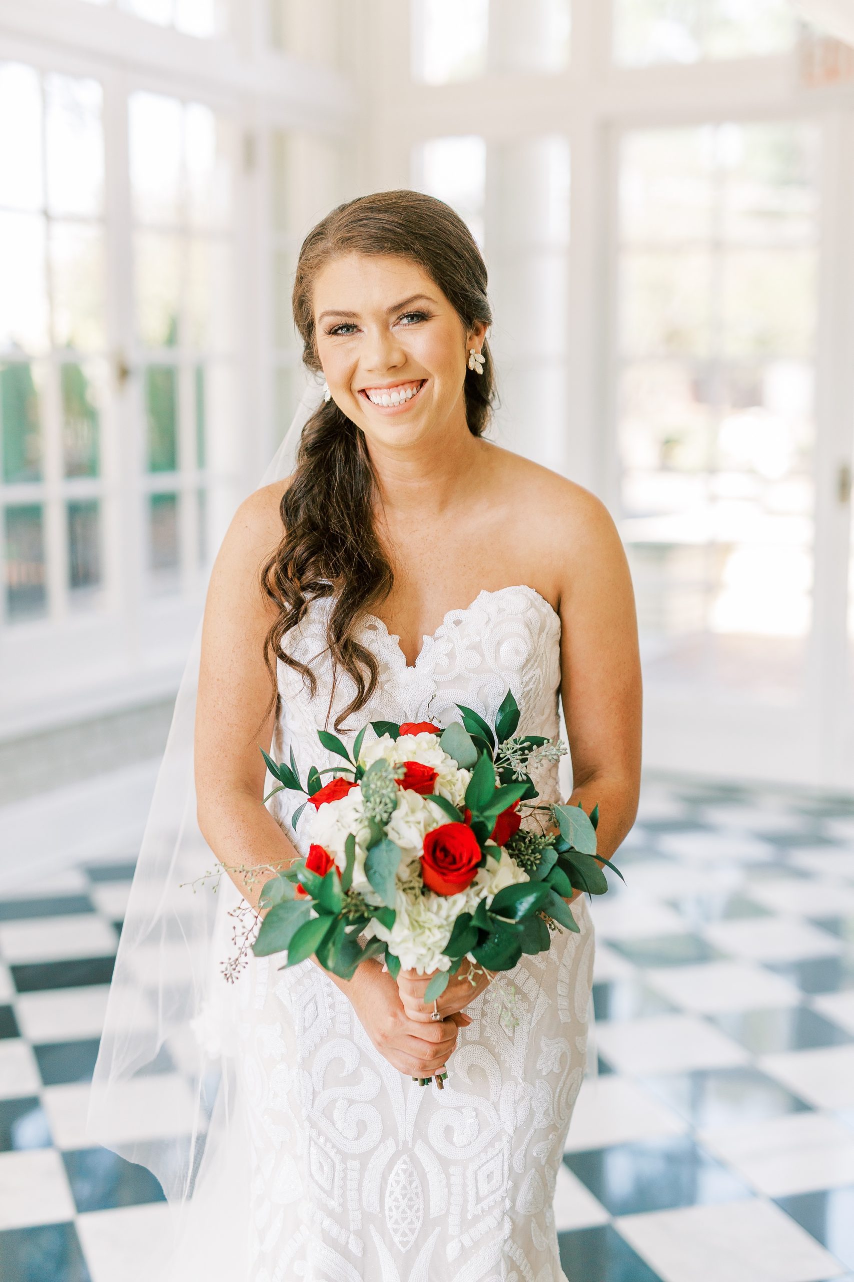 bride holds bouquet with red flowers