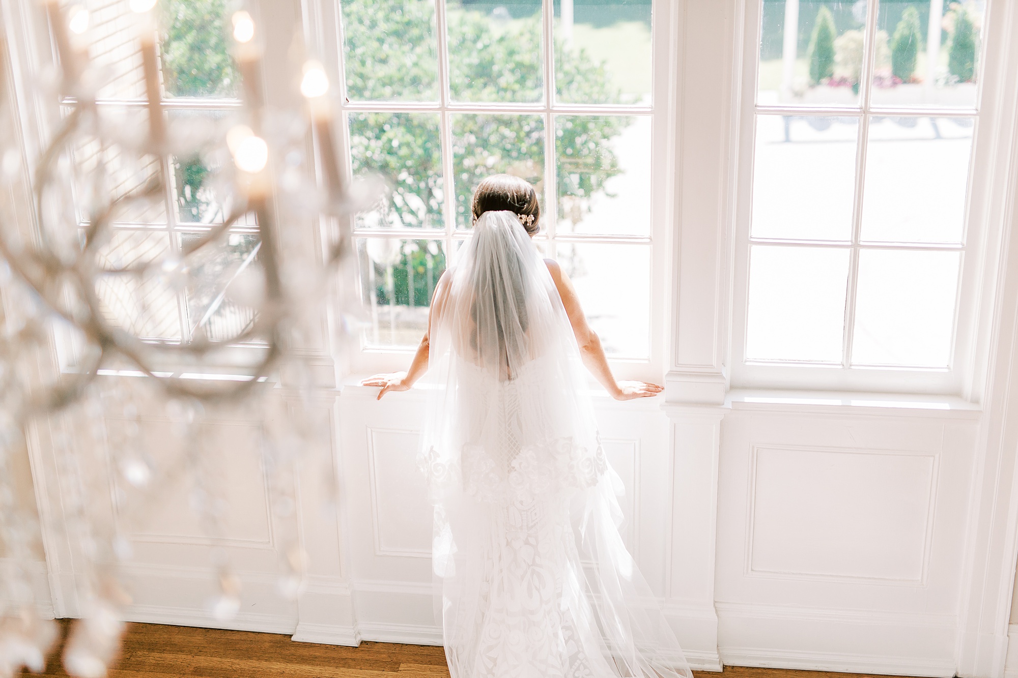 bride looks out window during Classic Charlotte Bridal Portraits