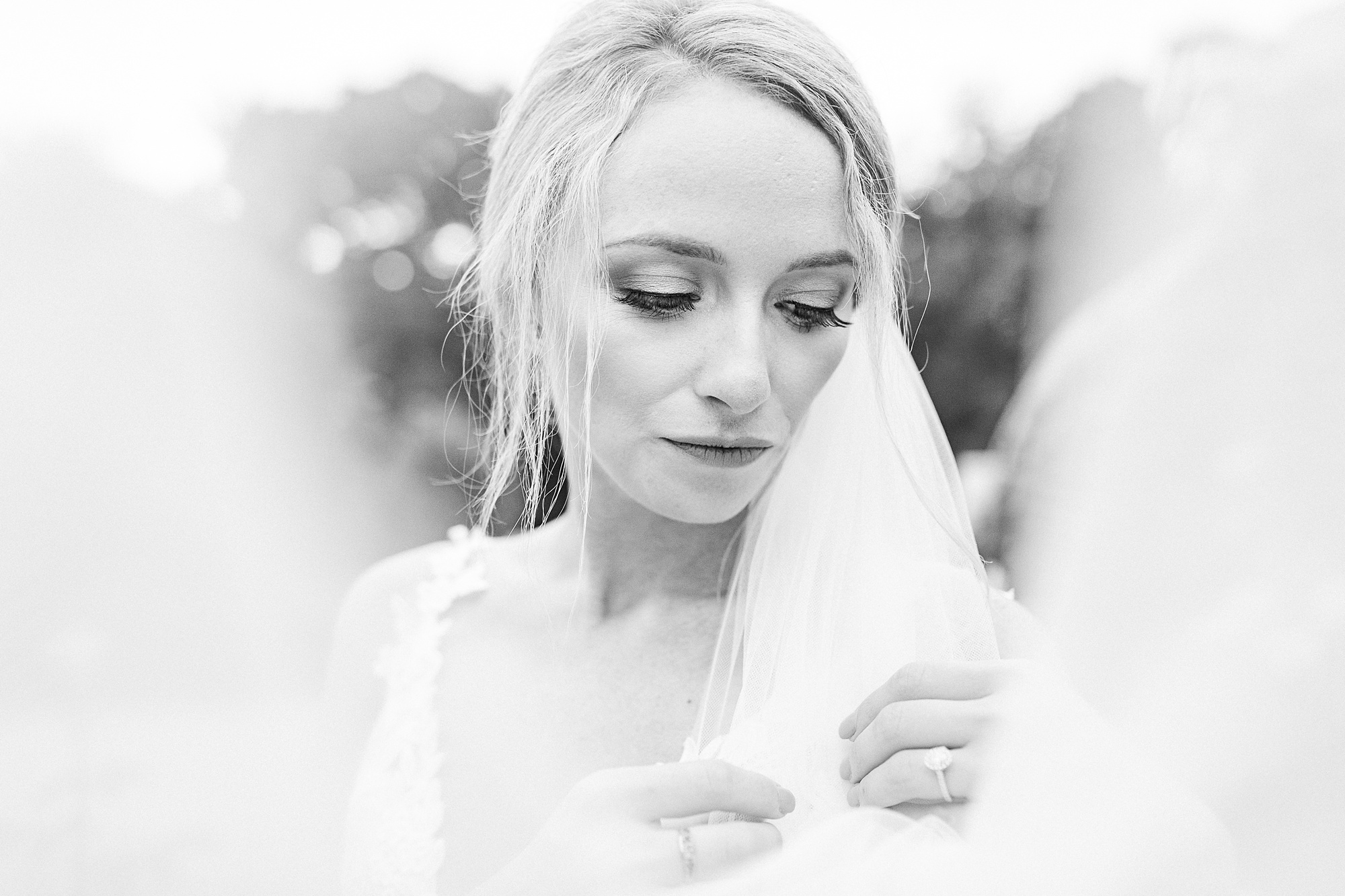 bride holds veil and looks over shoulder