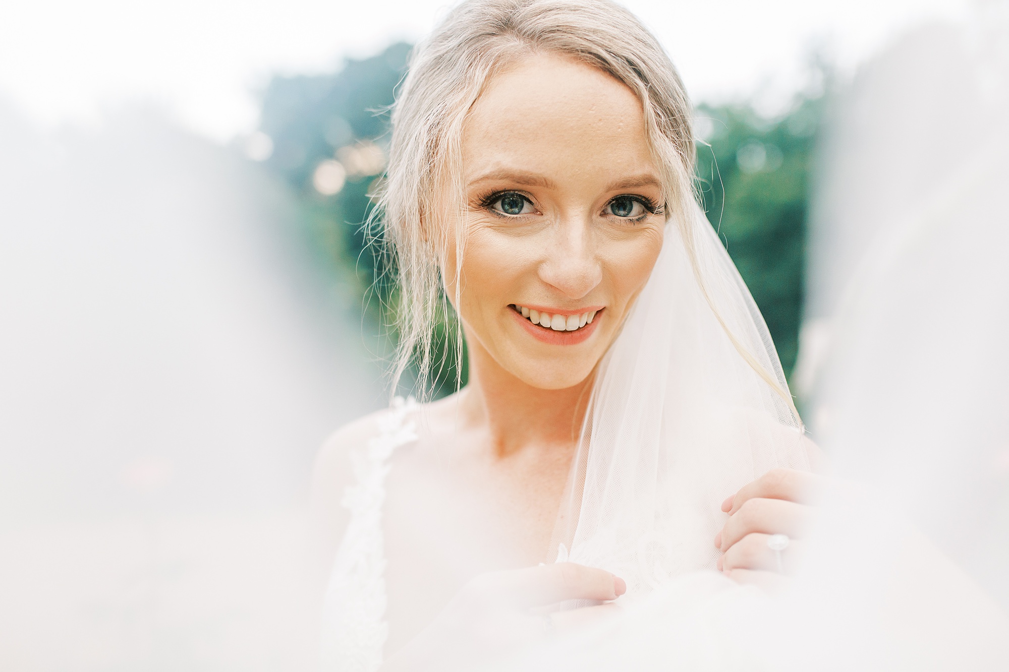 bride looks over the edge of her veil