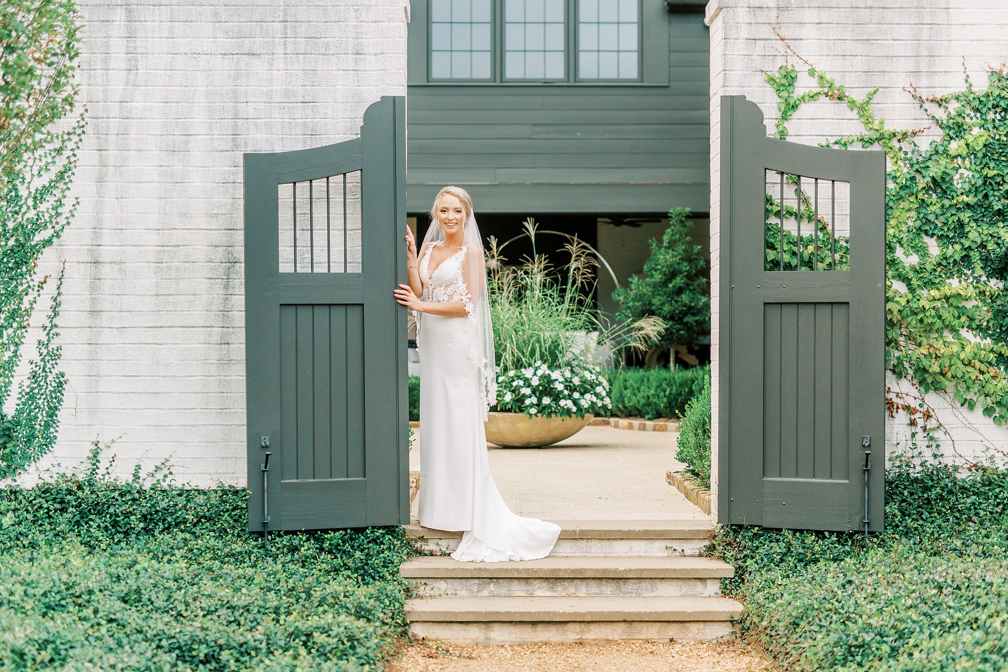 bride poses with gates at The Andrews Farm