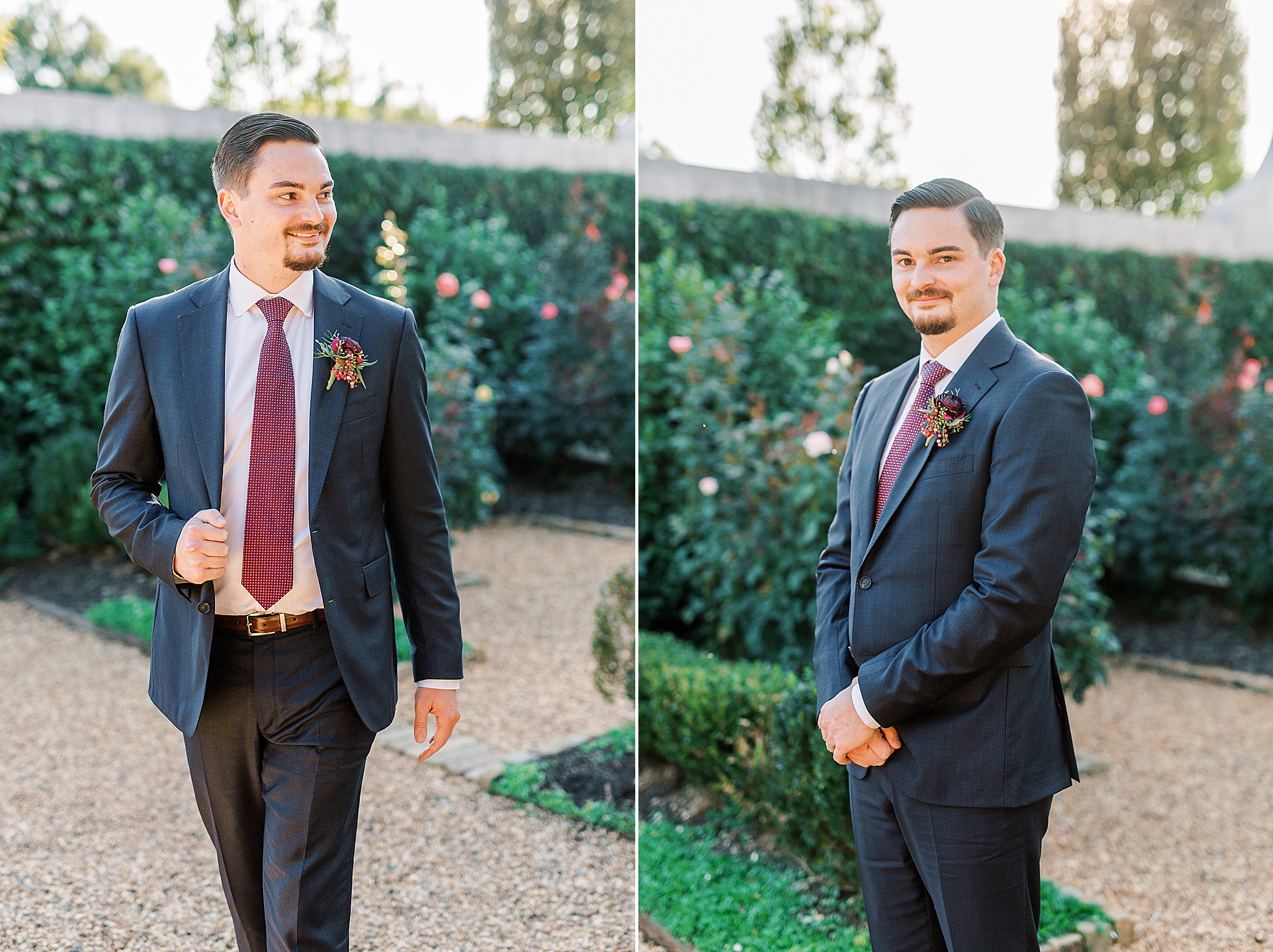 groom in navy suit with burgundy tie poses in garden