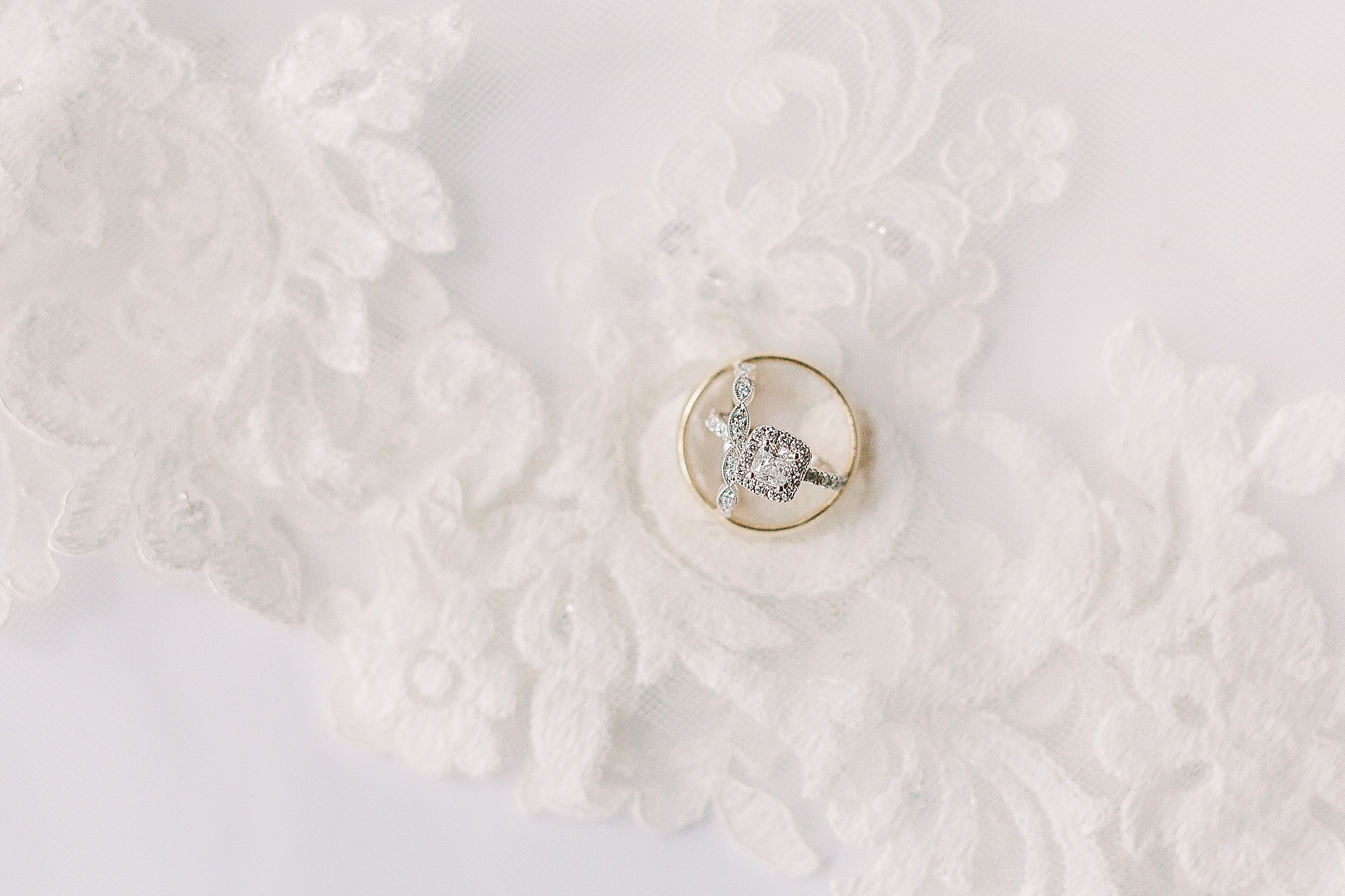 wedding rings lay on bride's veil