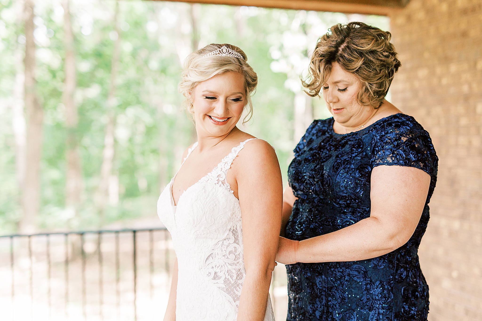 mom in navy blue gown helps bride prepare for Concord NC wedding