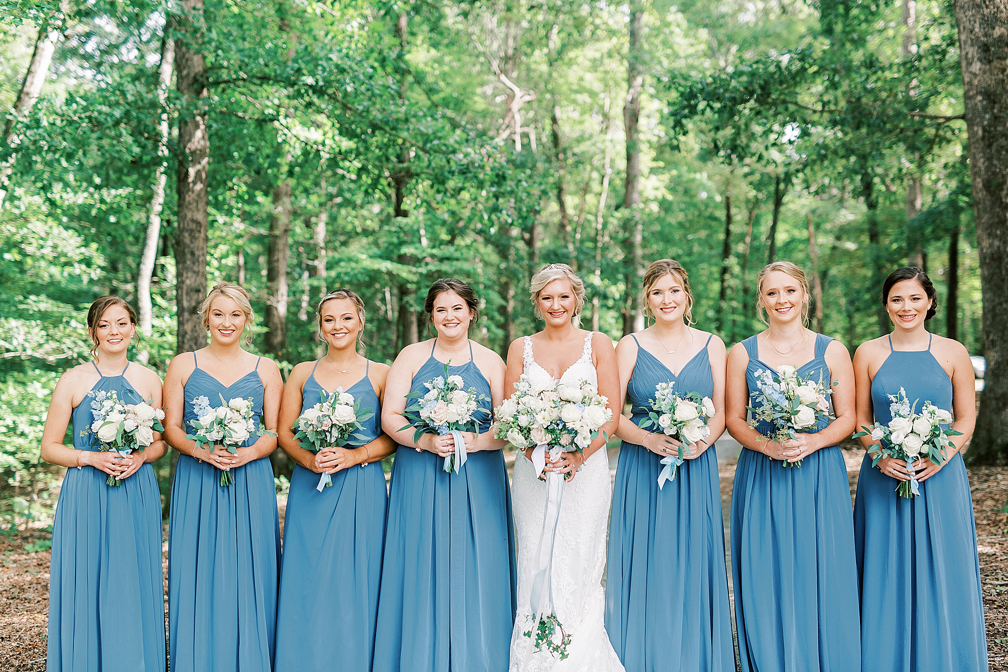 bride poses with bridesmaids in robin's blue dresses