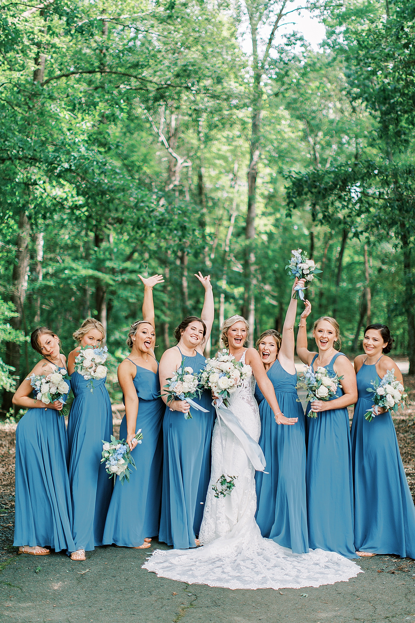 bridesmaids pose with bride while showing off bouquets