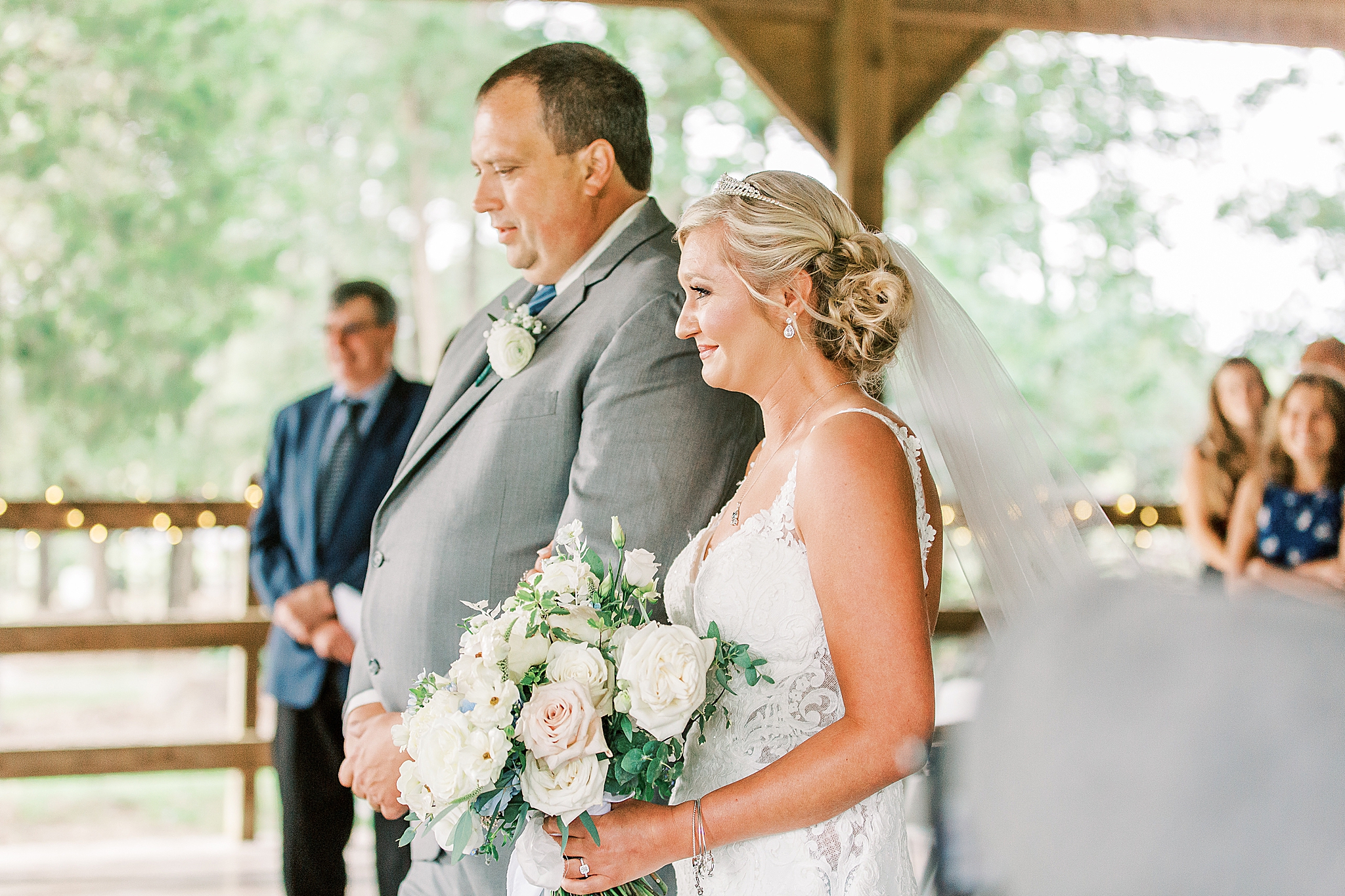 bride stands with dad during wedding ceremony