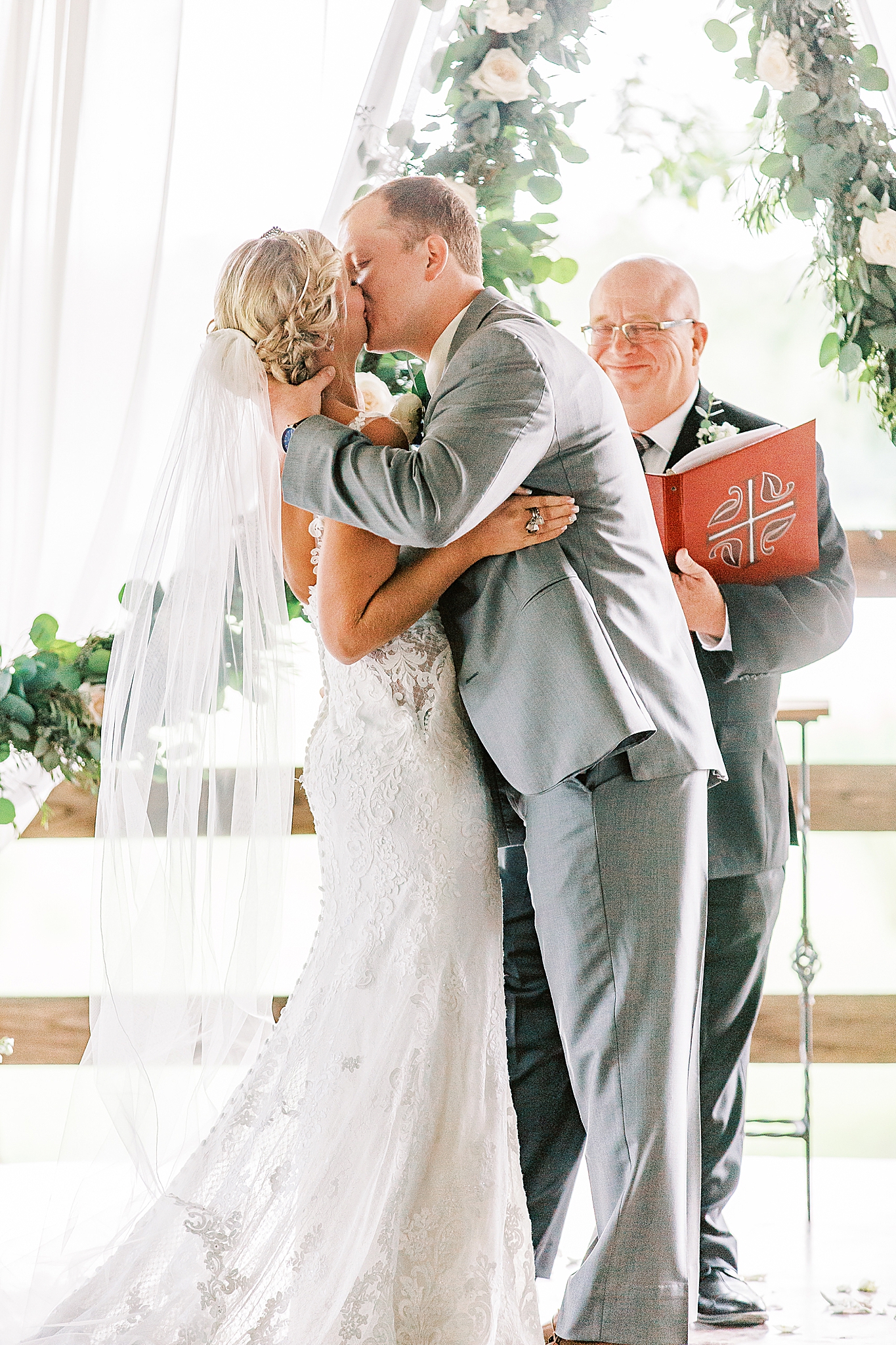 first kiss for bride and groom during wedding ceremony