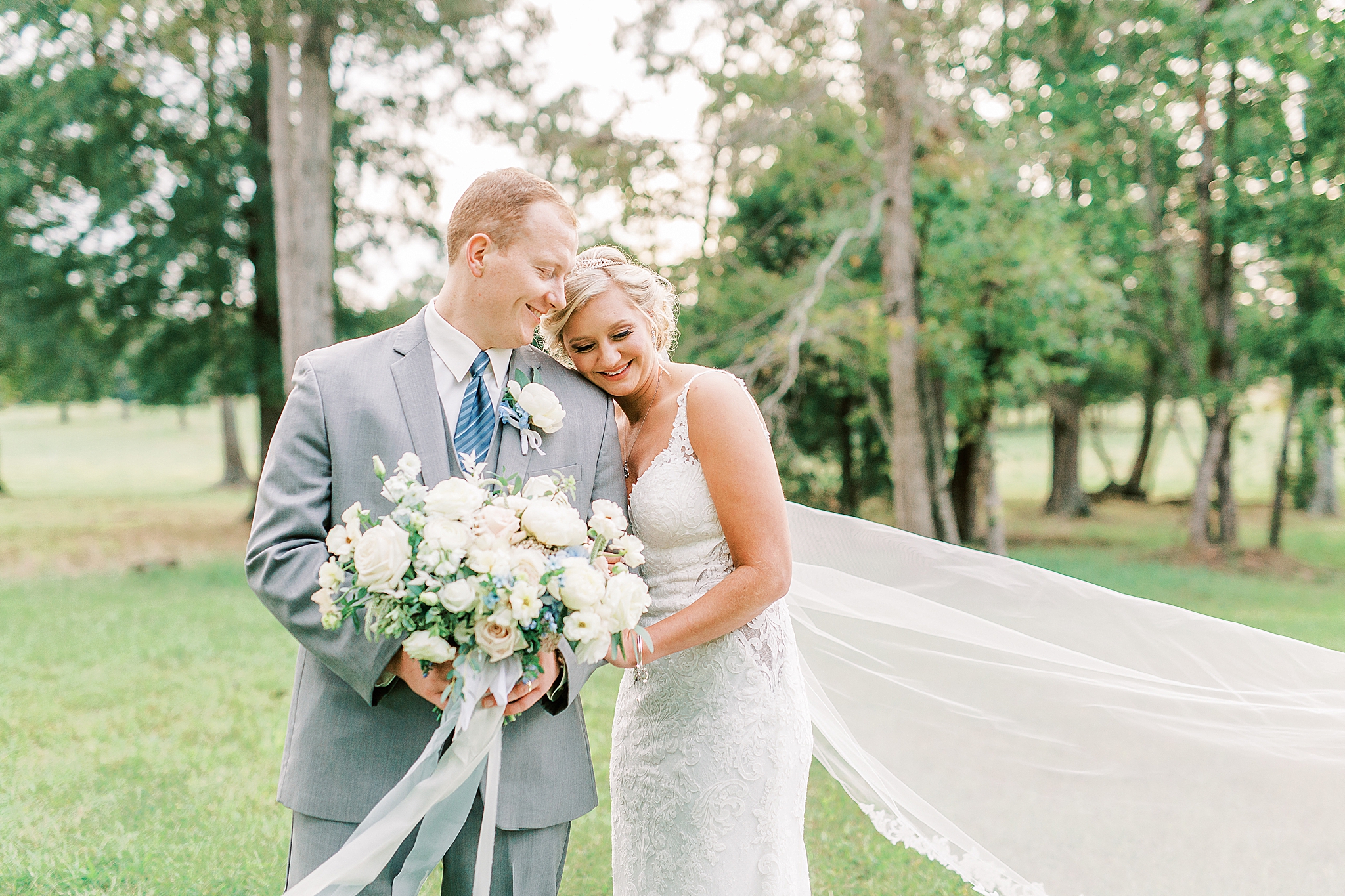 bride leans against groom with veil floating behind