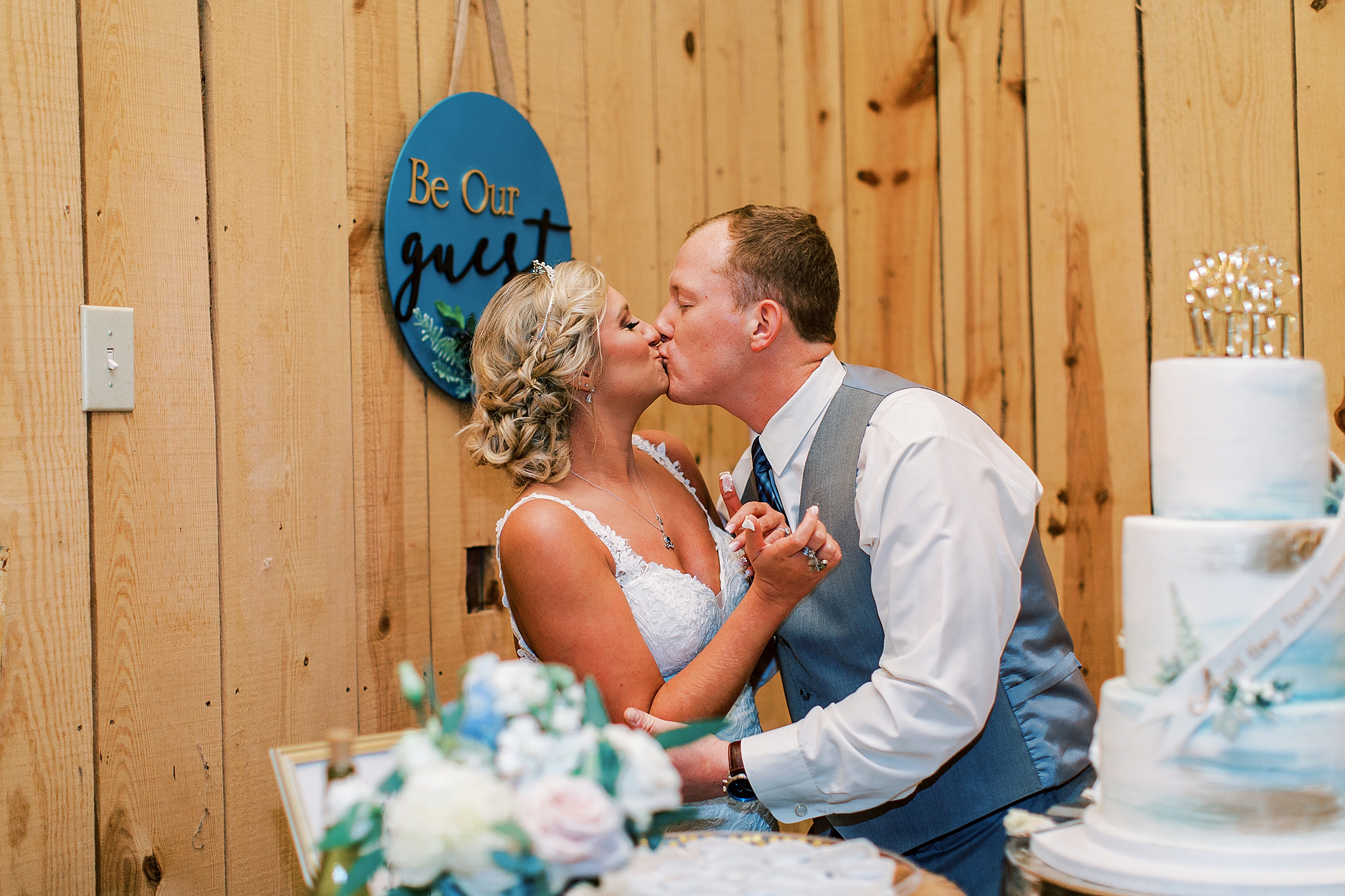 newlyweds kiss after cutting wedding cake at the Farm at Brusharbor