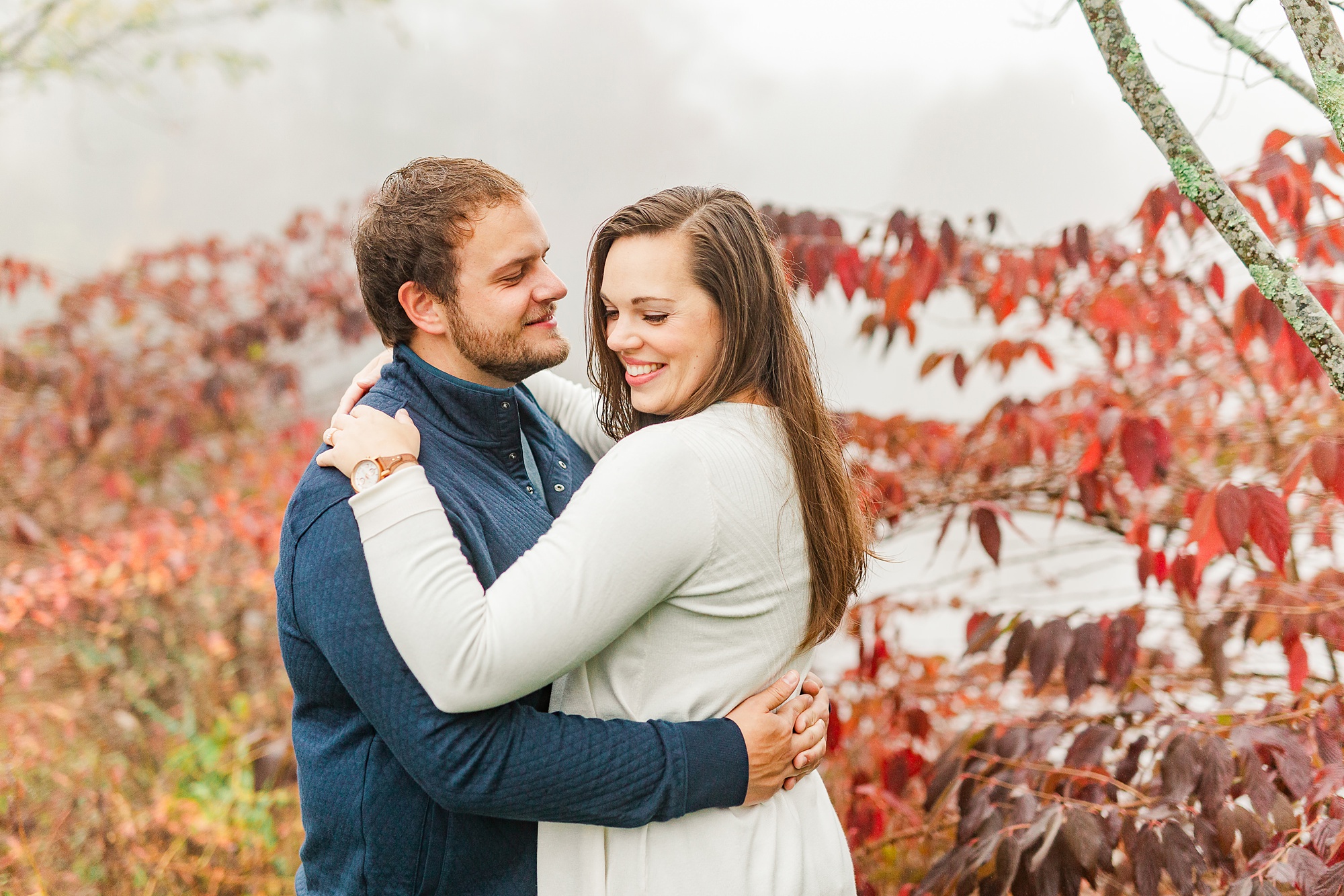 bride laughs over shoulder during engagement photos in Blowing Rock