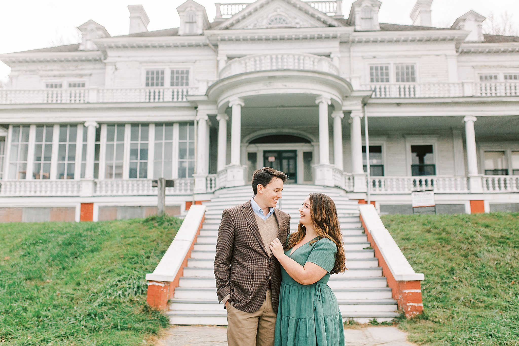 engaged couple poses in front of Moses Cone Manor