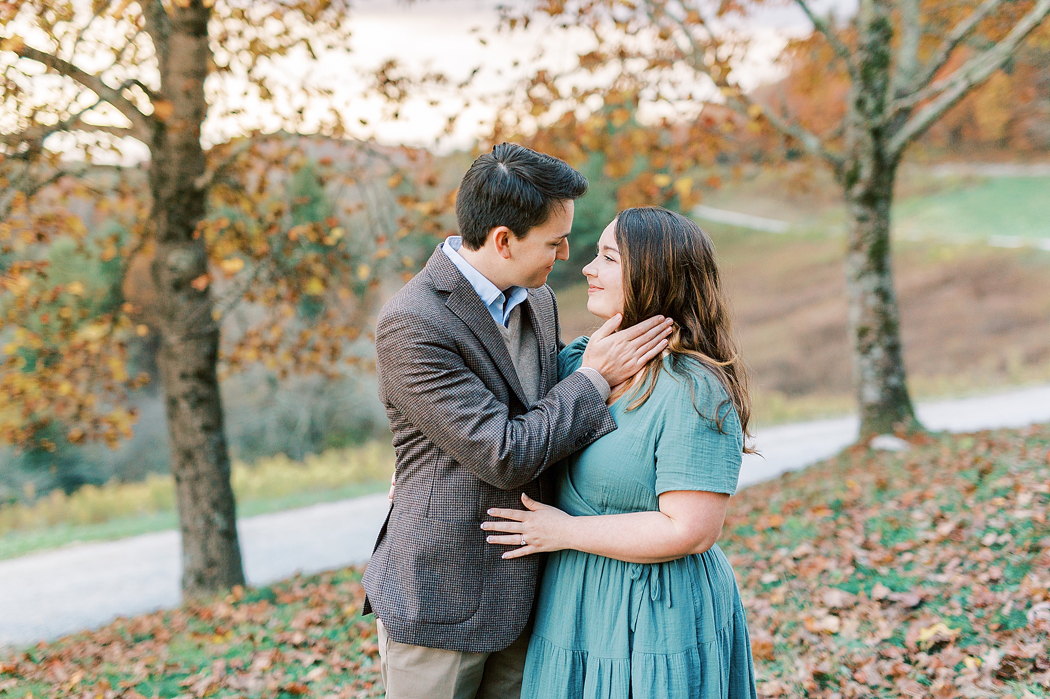 groom leans to kiss bride during NC engagement session
