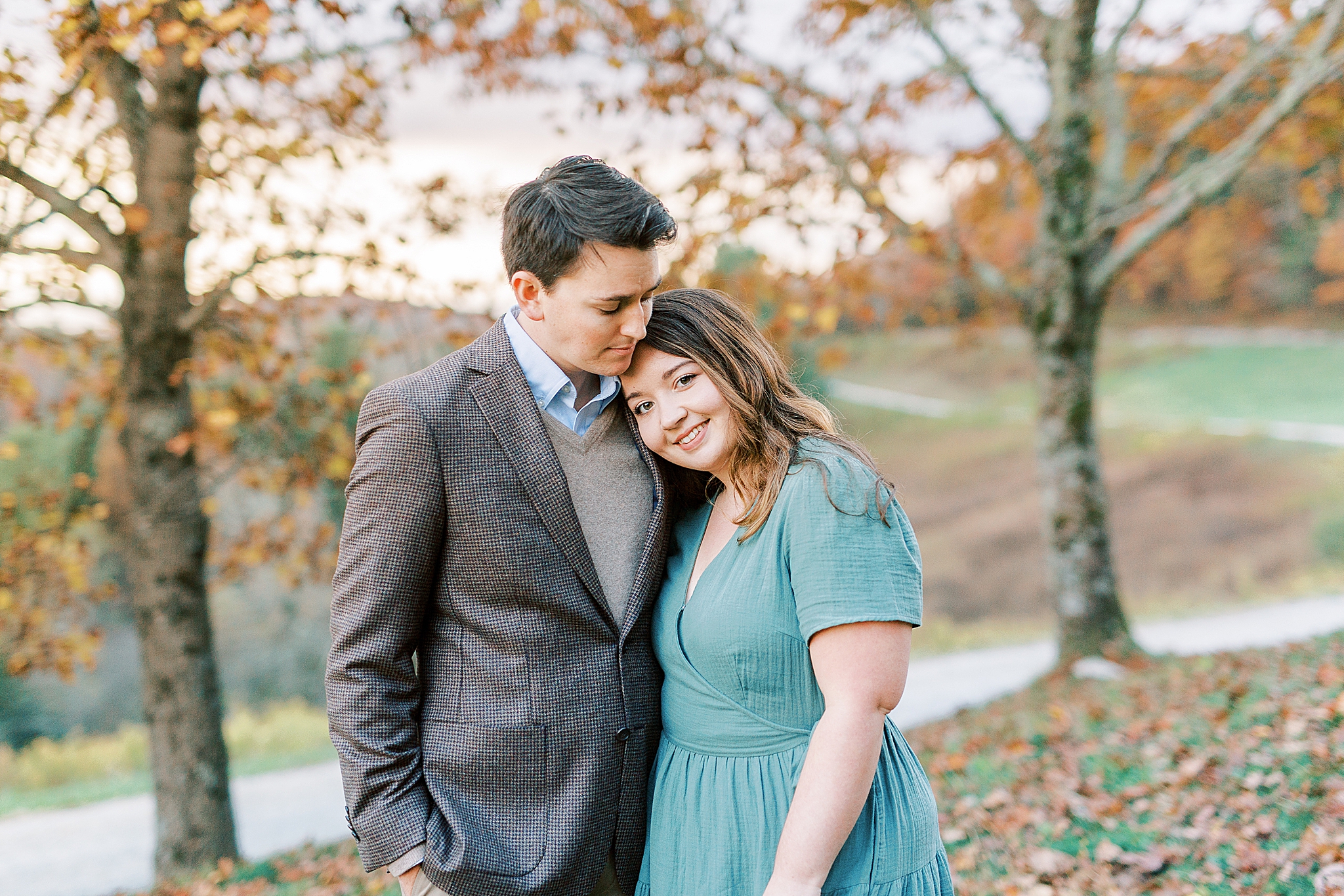 bride leans on groom during North Carolina engagement photos in the fall