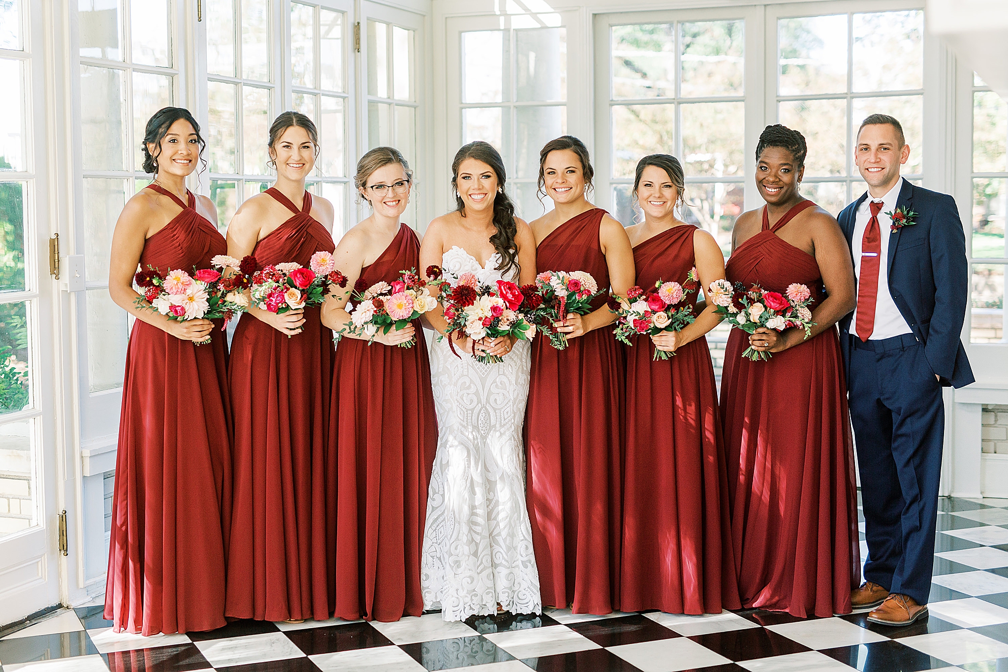 bridesmaids in red gowns pose inside Separk Mansion
