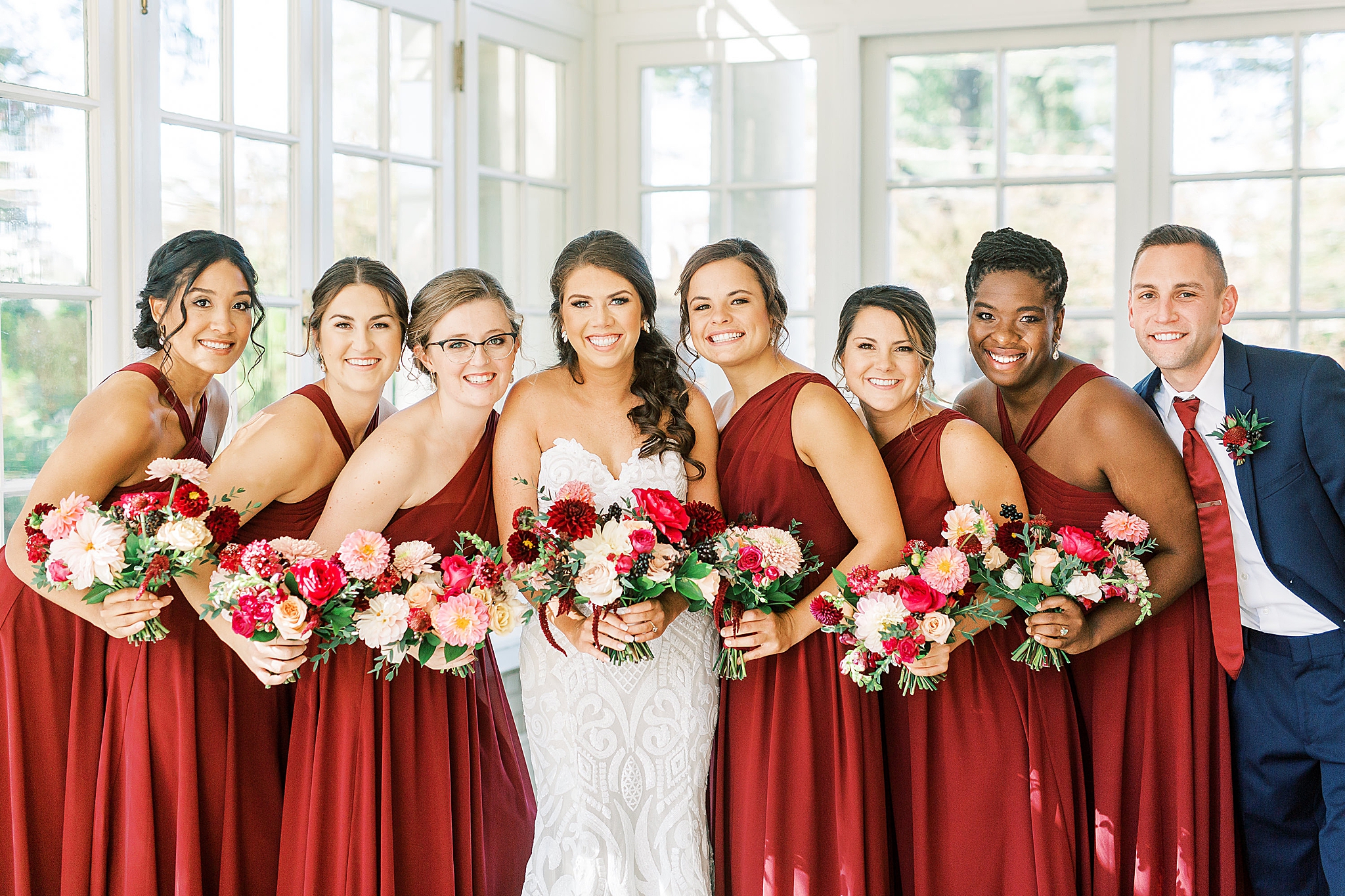 bridesmaids in red gowns for fall wedding pose at Separk Mansion
