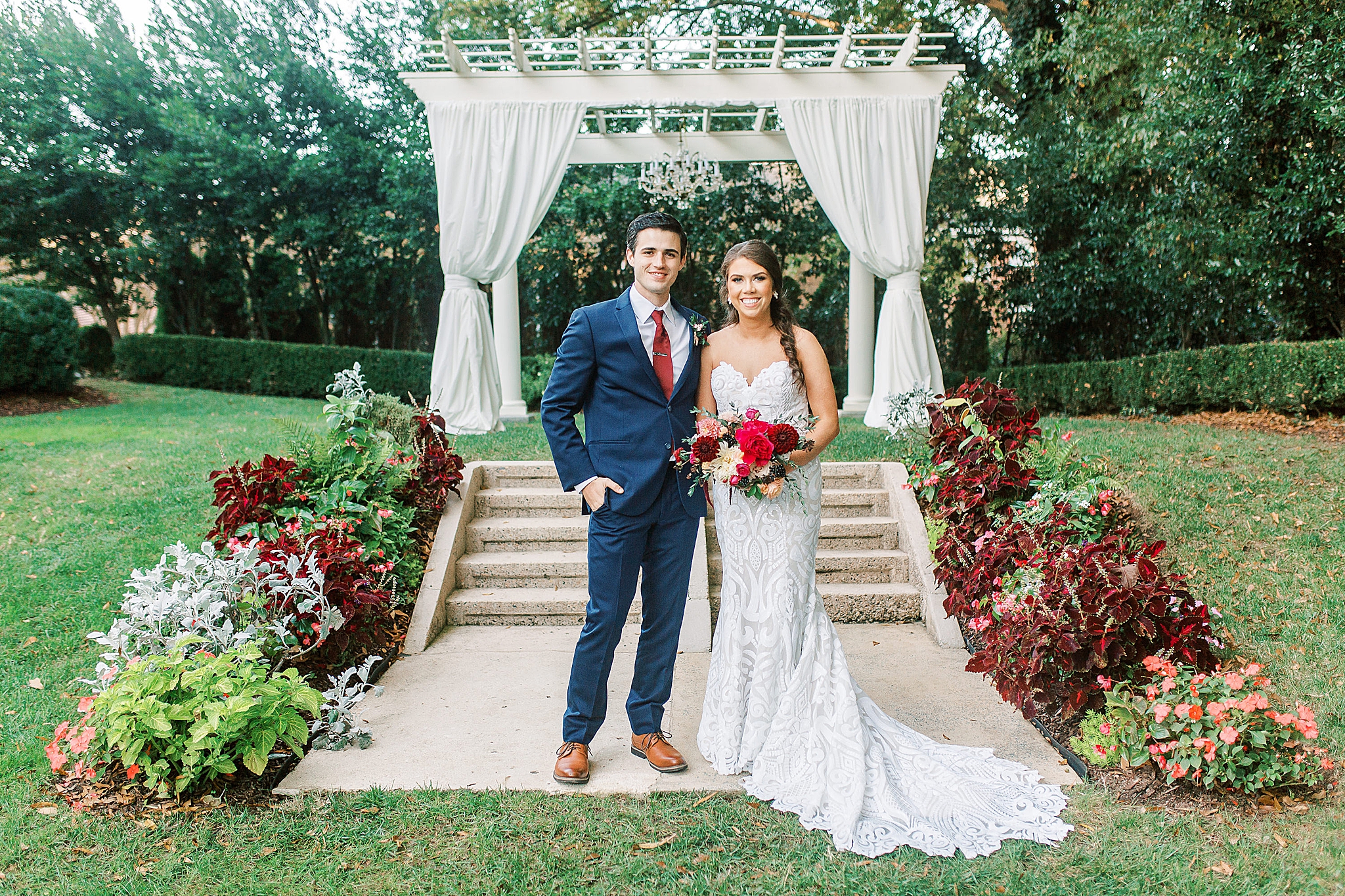 newlyweds pose by arch in gardens at Separk Mansion