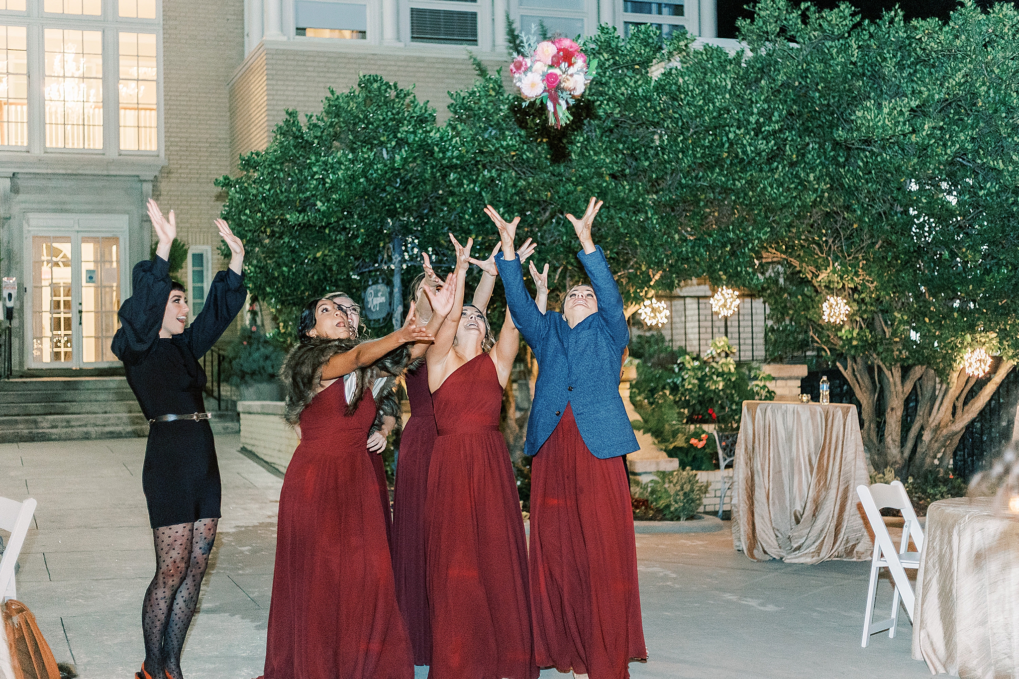 bridesmaids reach for bouquet during toss