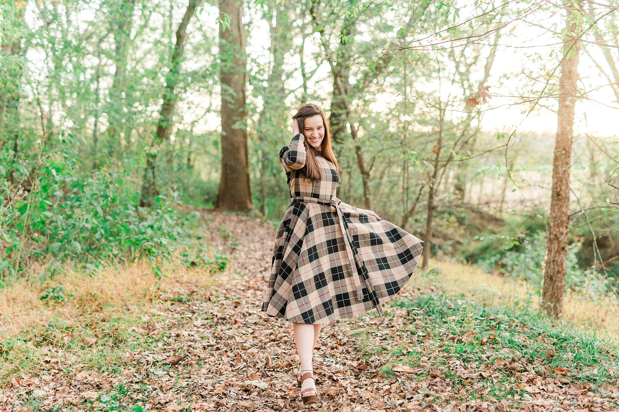 senior twirls dress in woods at Sloan Park
