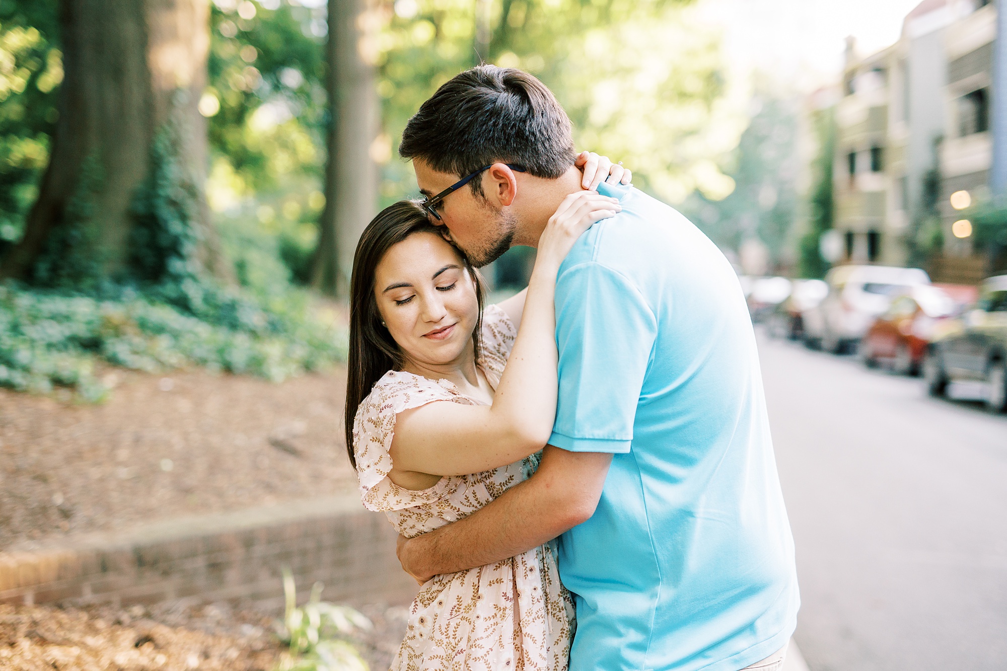 groom kisses bride's head during engagement photos