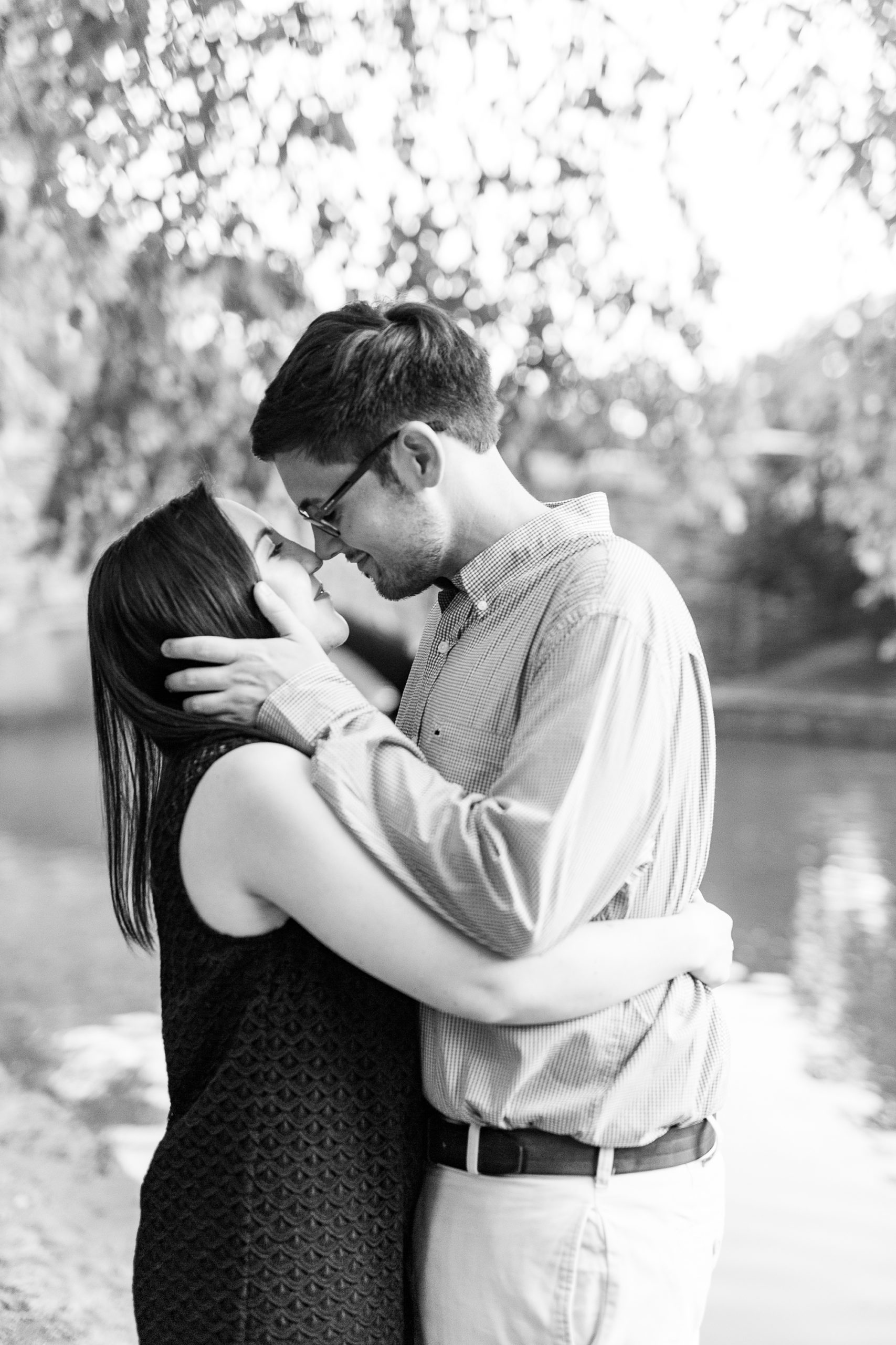 groom leans to kiss bride during engagement photos