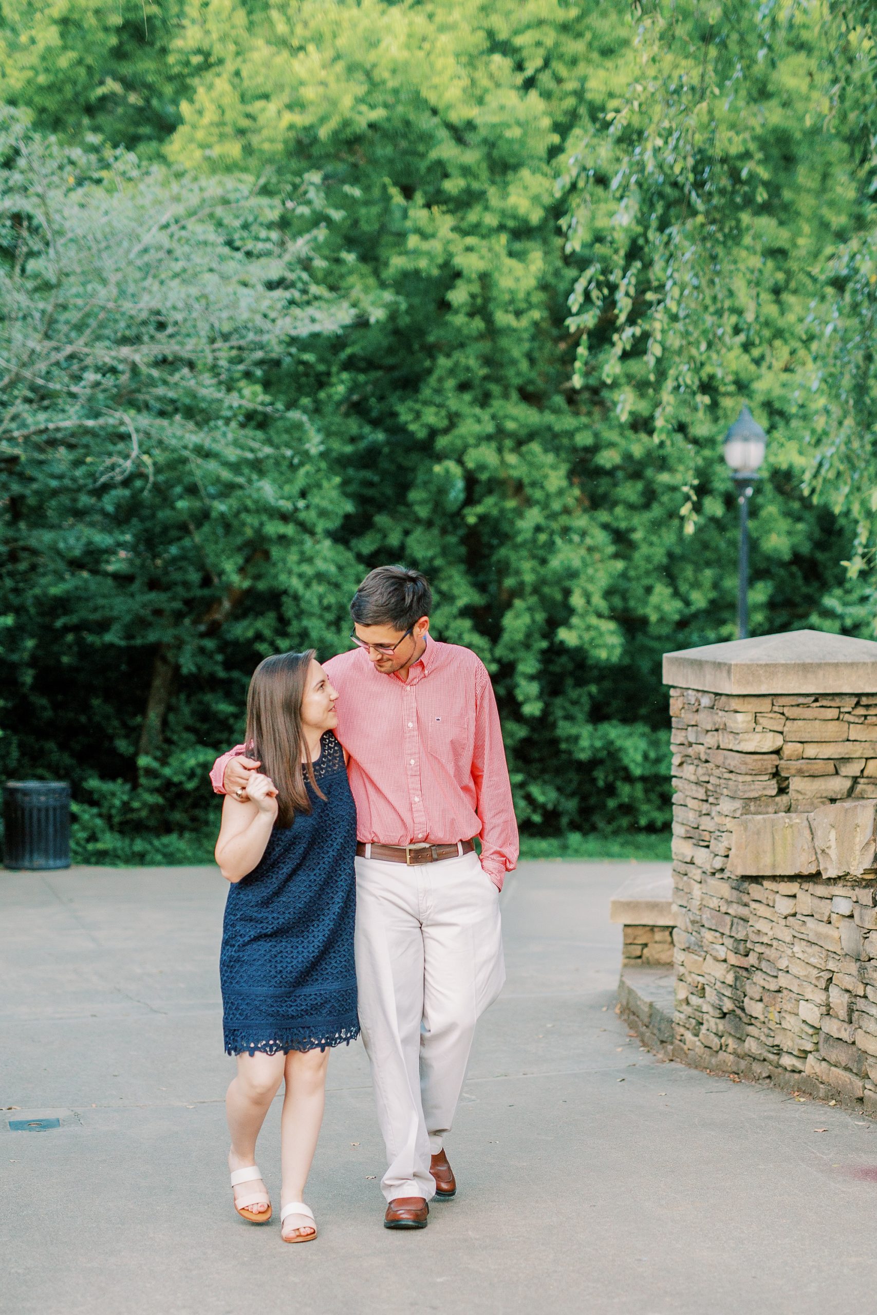 couple walks near brick wall in Freedom Park