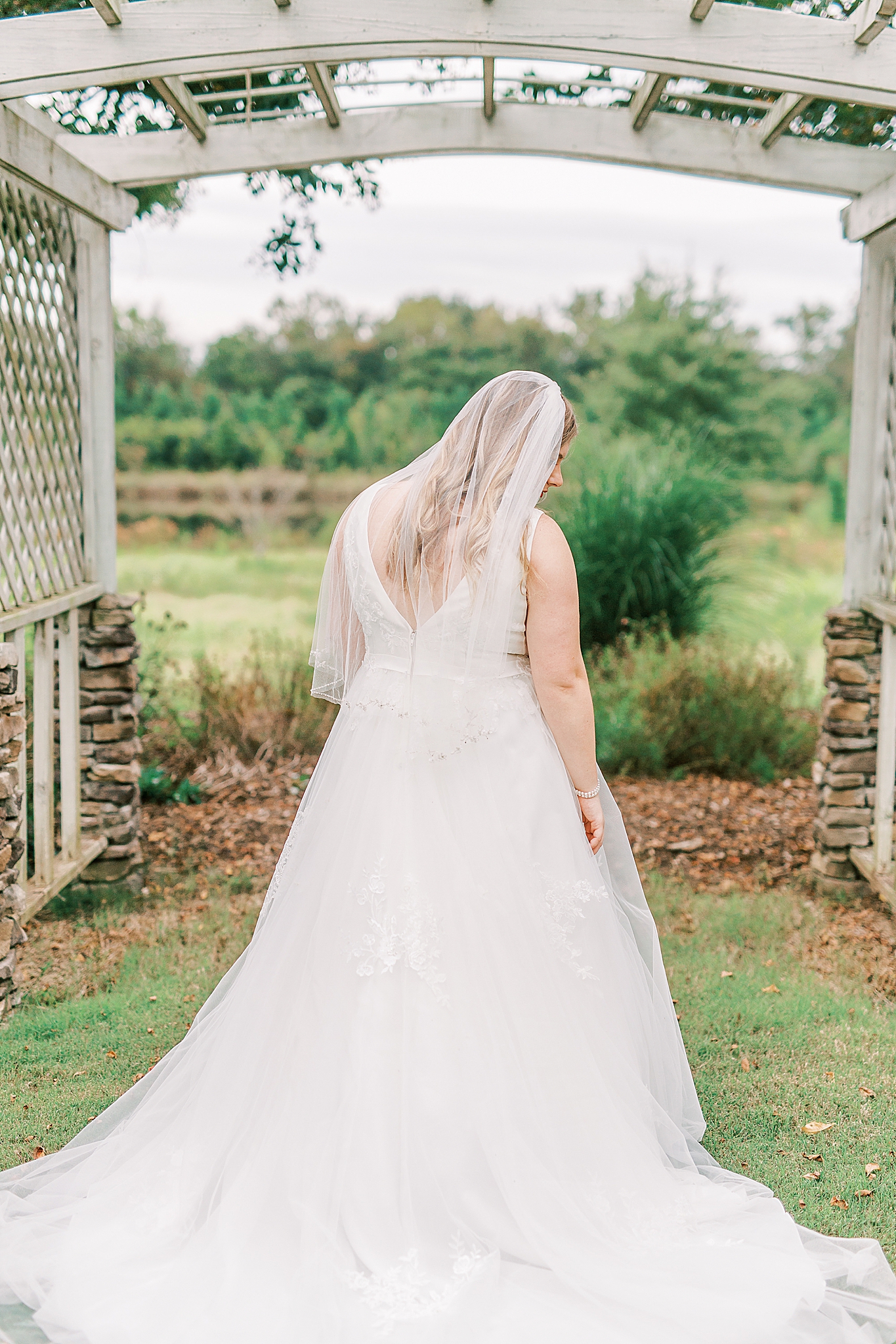 bride looks over shoulder with veil down back