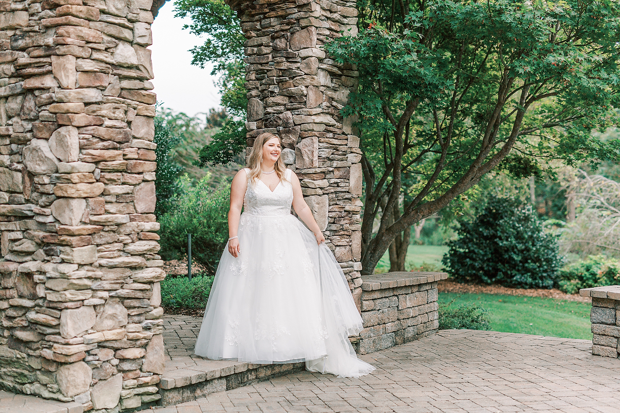 bride stands on edge of arbor in Cleveland NC