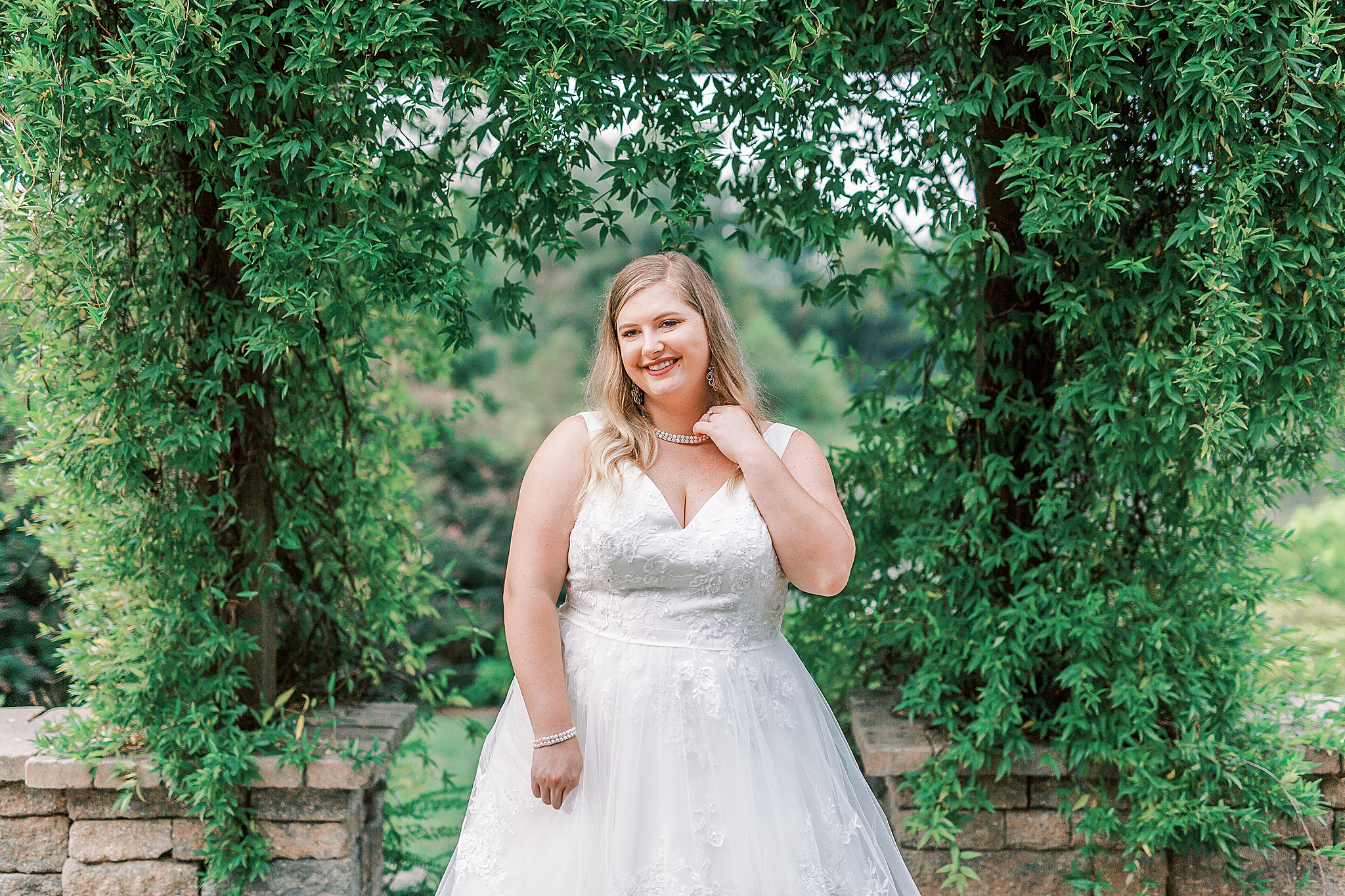 bride laughs while standing in front of ivy covered wall