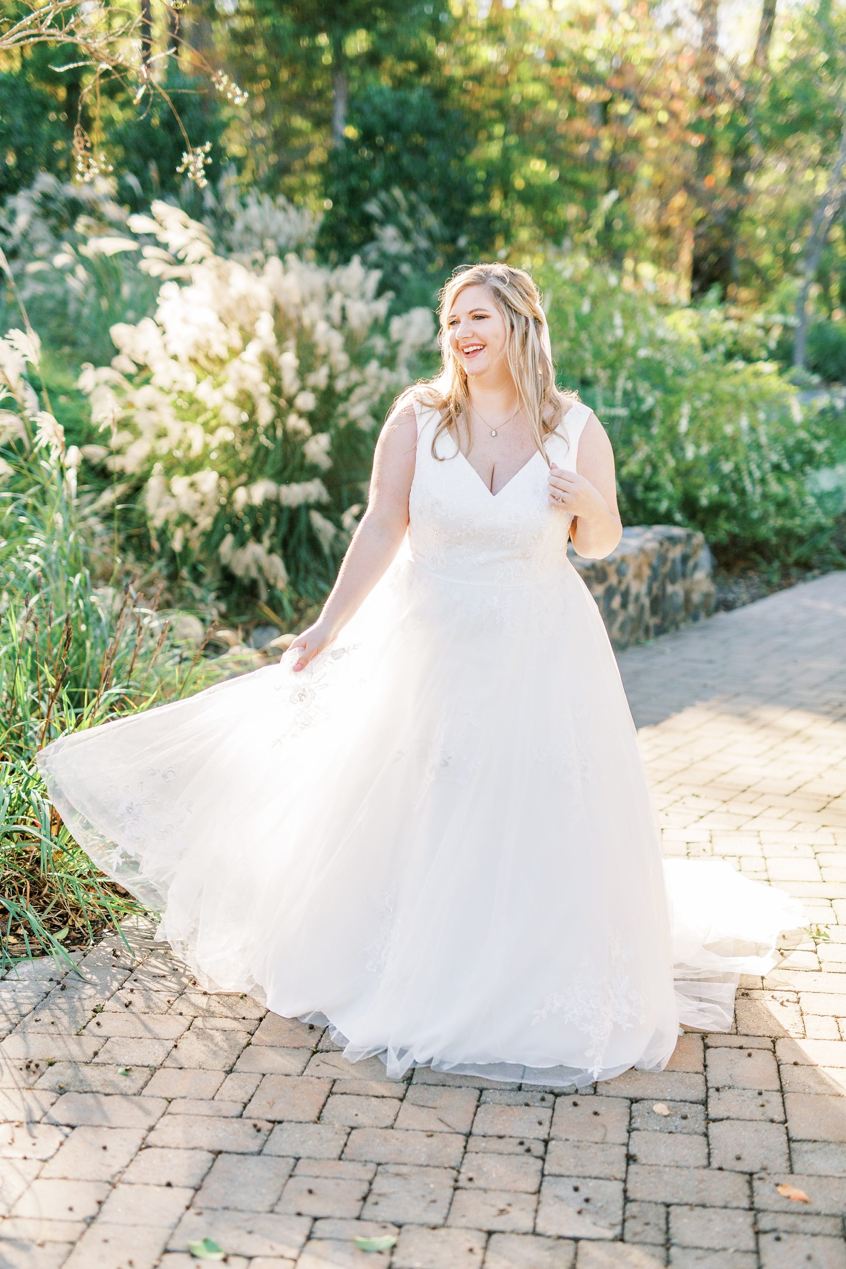 bride twirls wedding gown during portraits at the Arbors Events