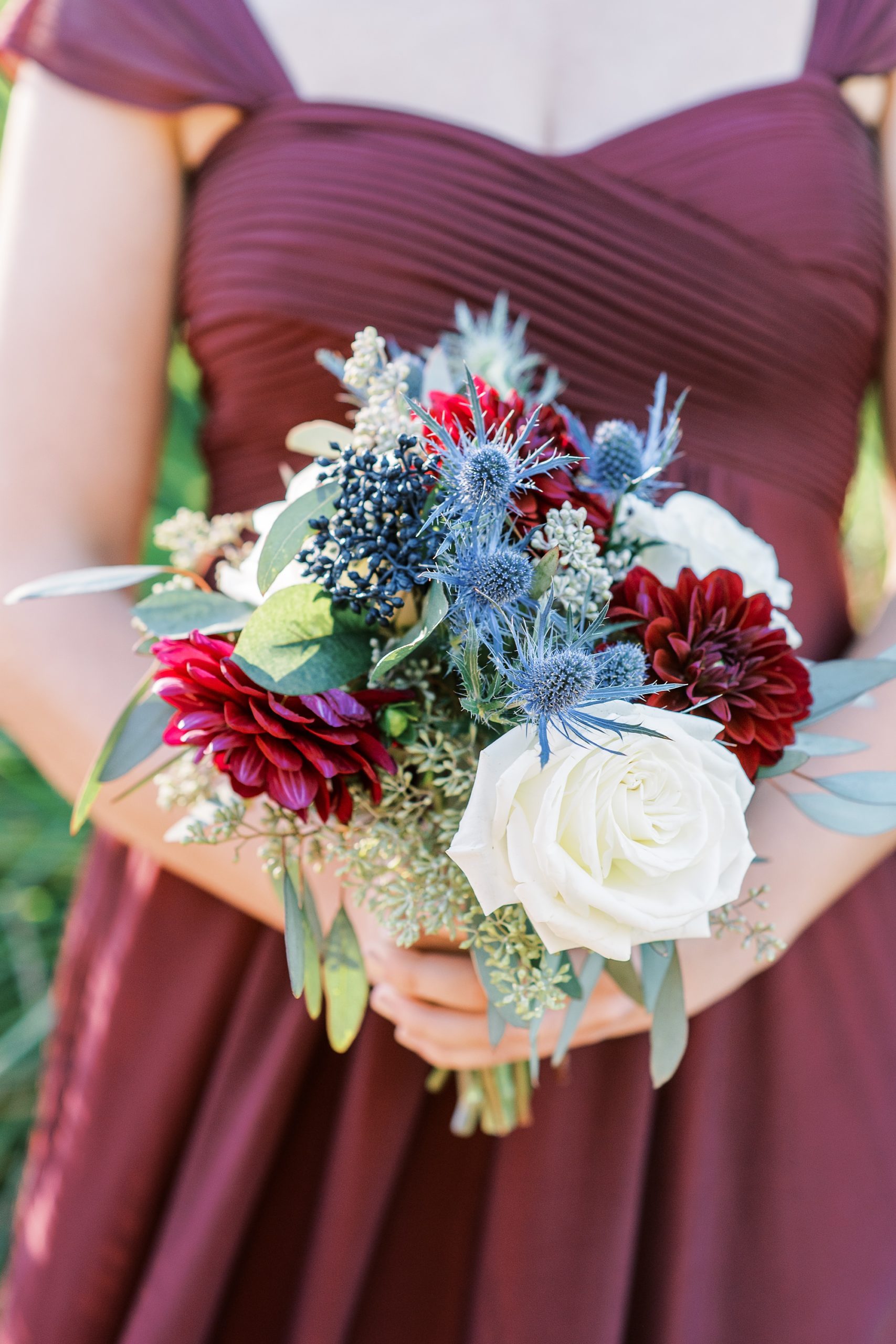 bridesmaid in mulberry gown holds bouquet