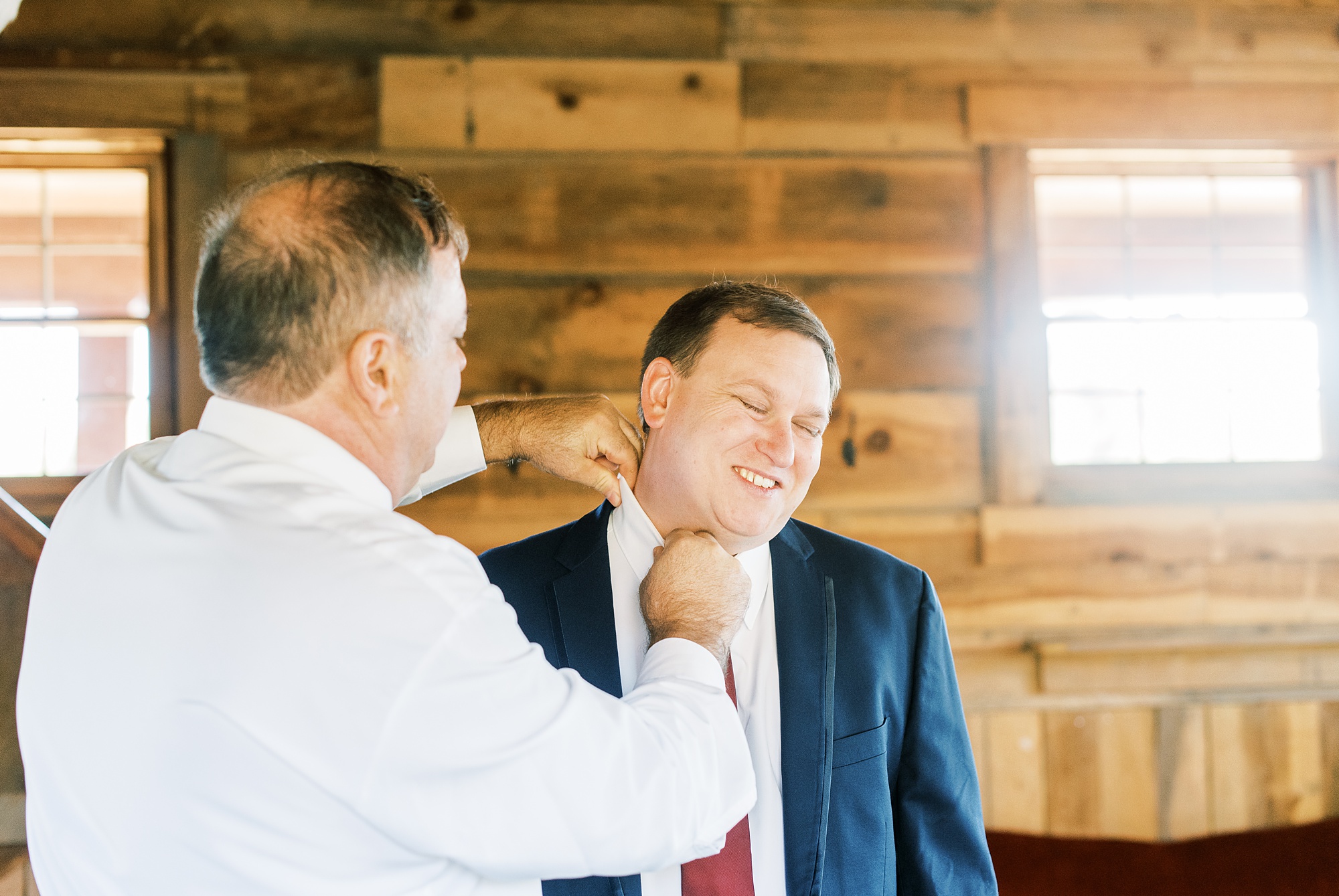 groomsman adjusts groom's collar