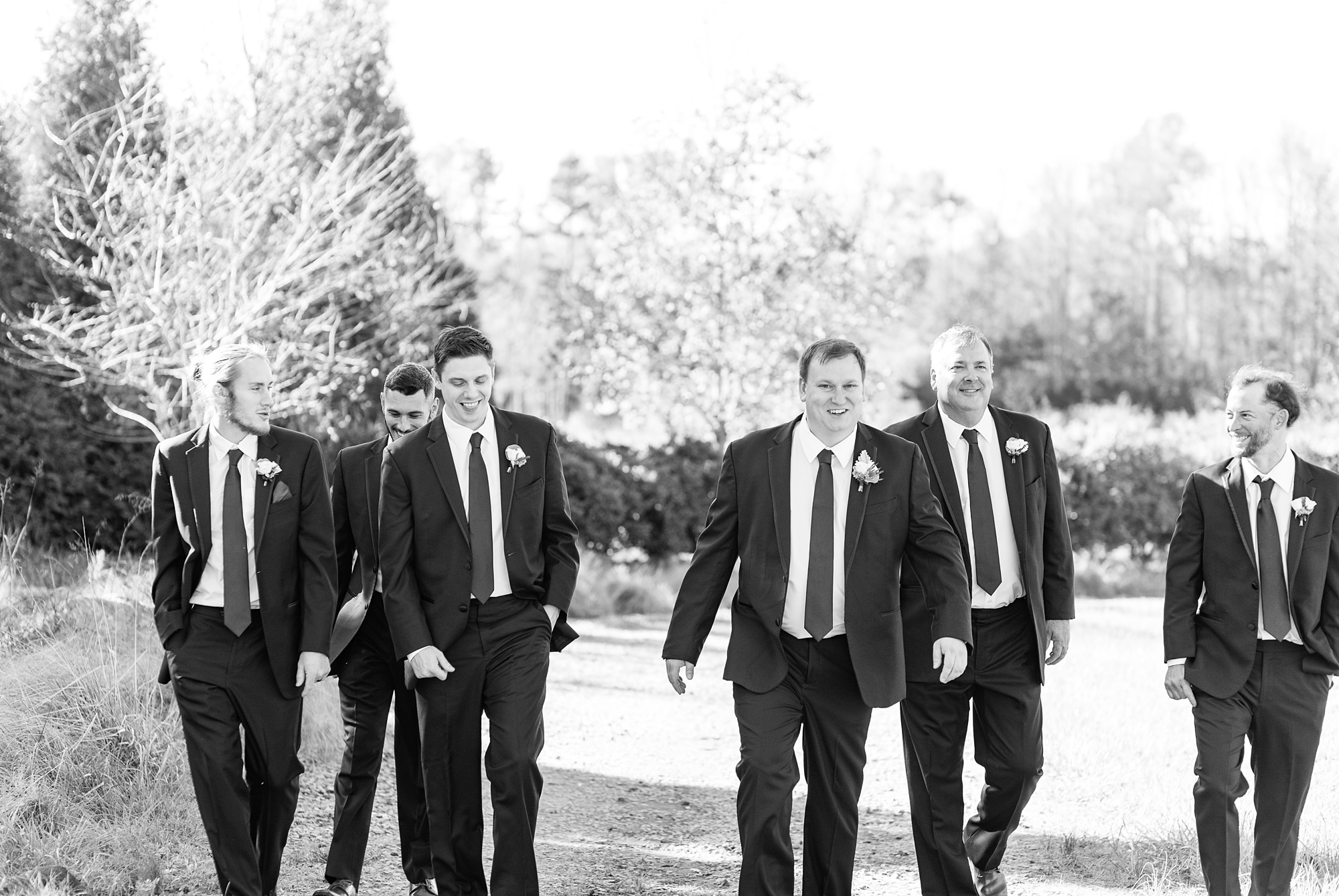 groom and groomsmen walk before Arbors Events wedding