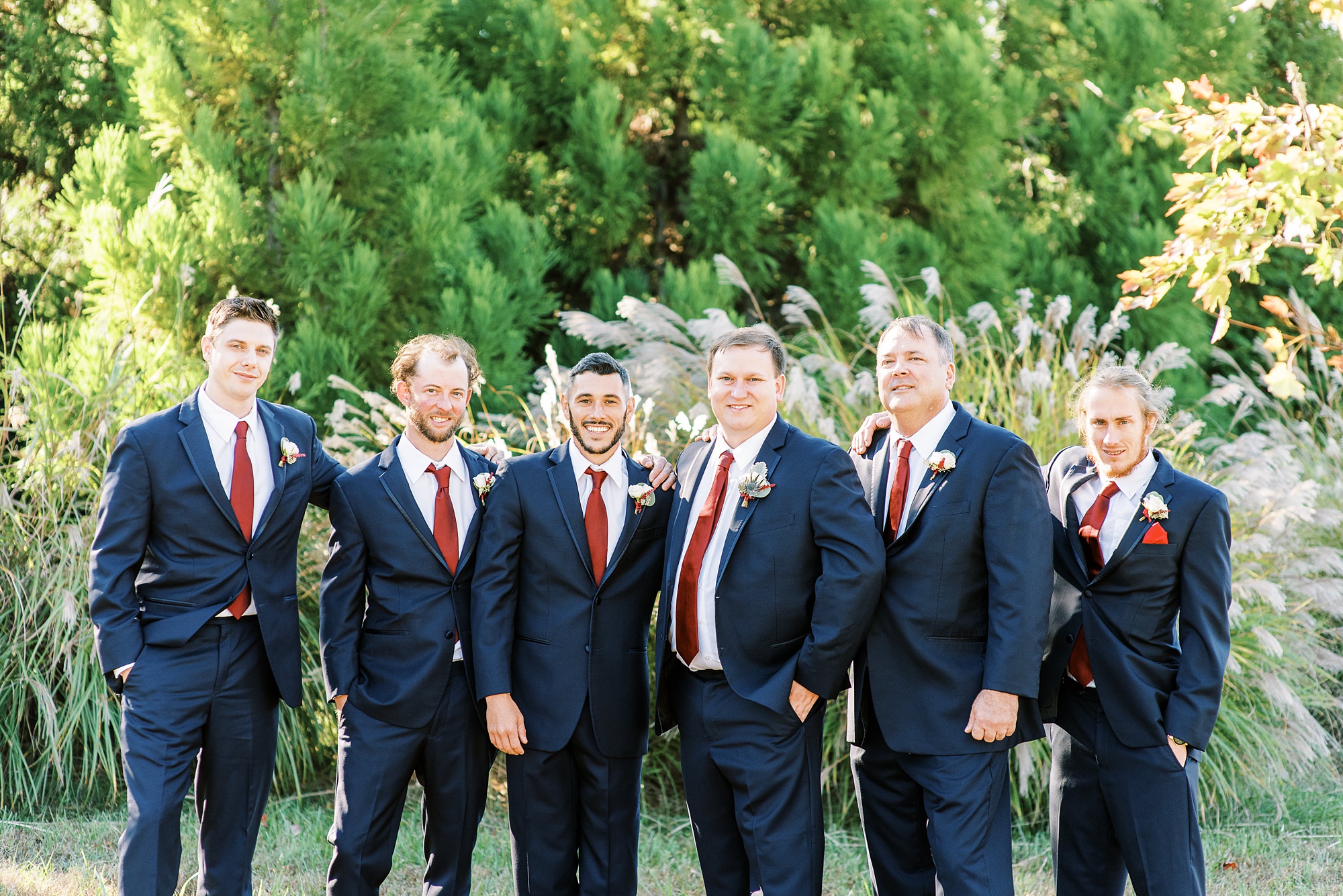 groom poses with groomsmen during NC wedding day