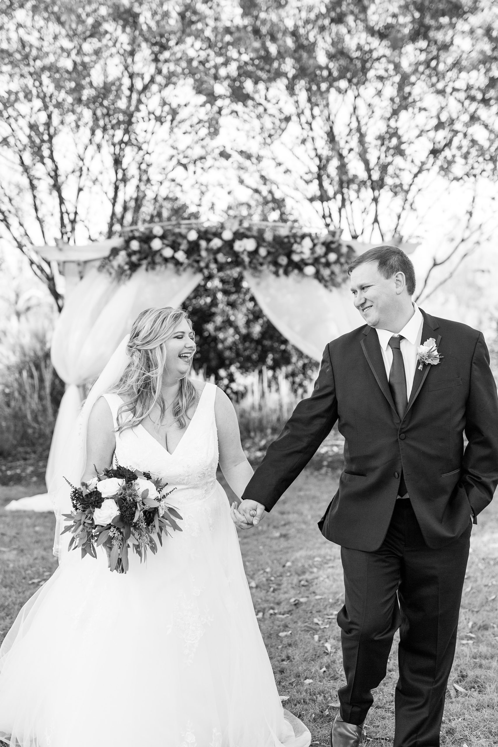 bride and groom walk away from floral arbor in Cleveland NC