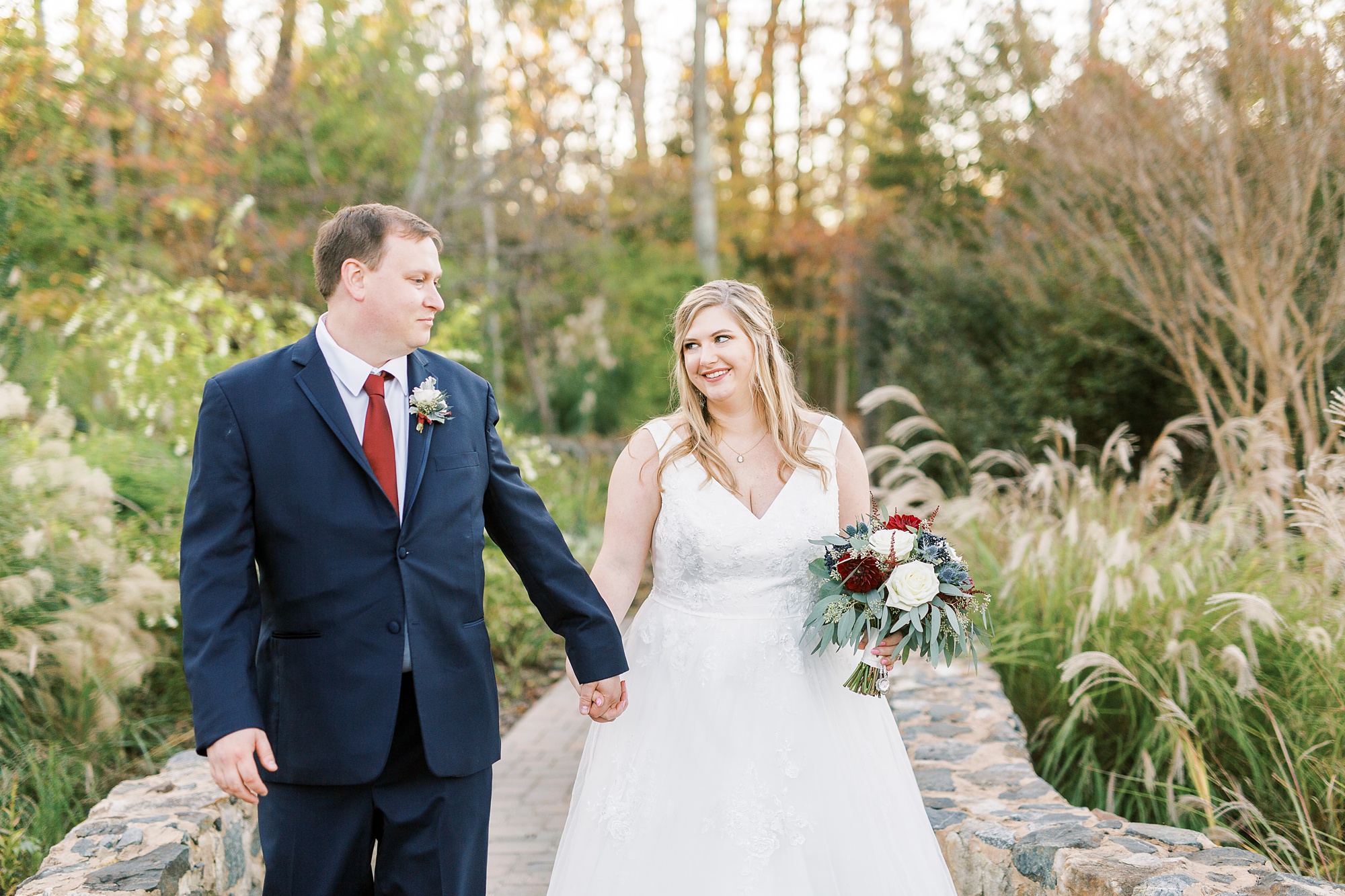 newlyweds walk through the Arbors Events gardens