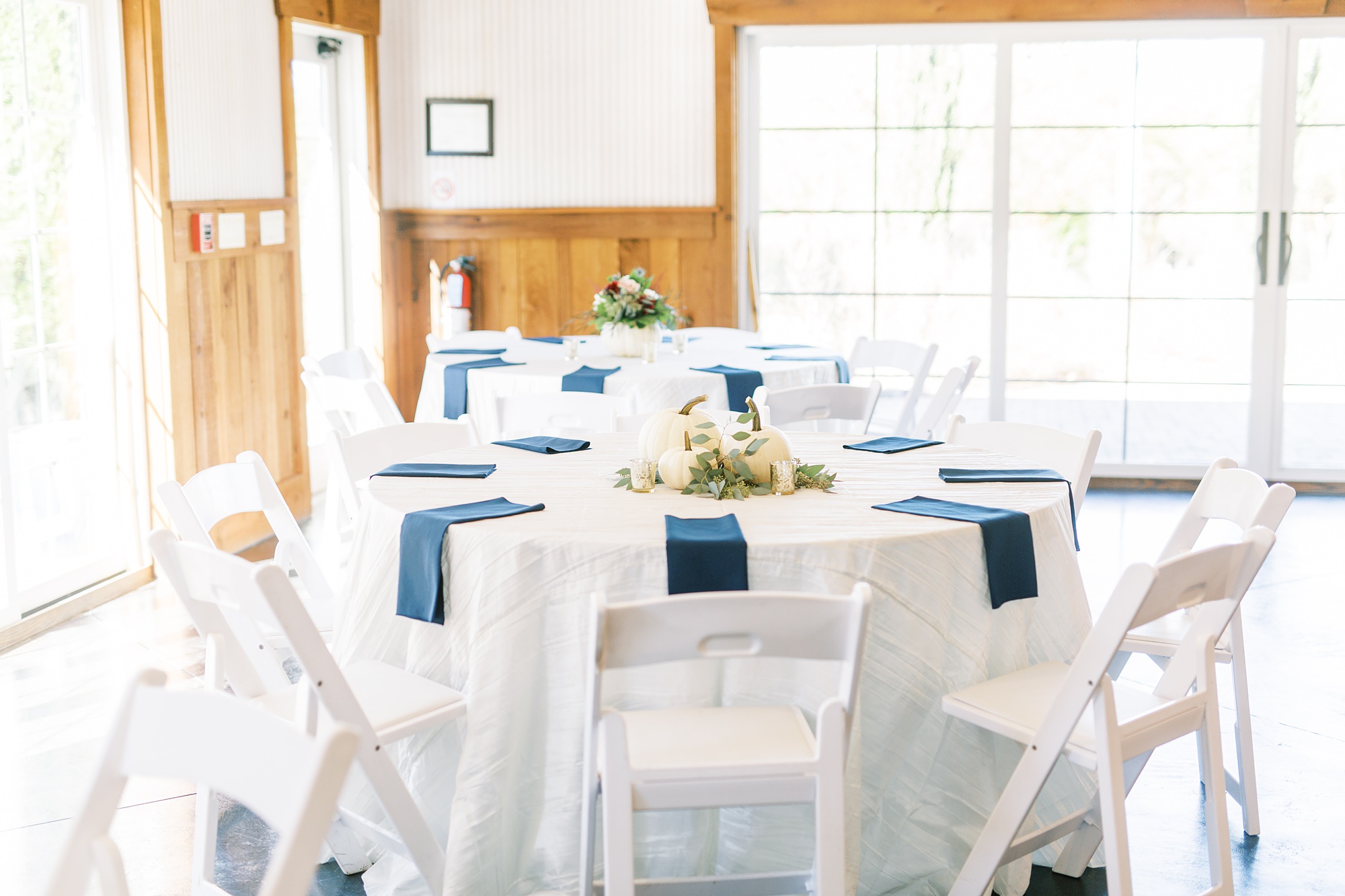 the Arbors Events wedding reception tables with navy napkins