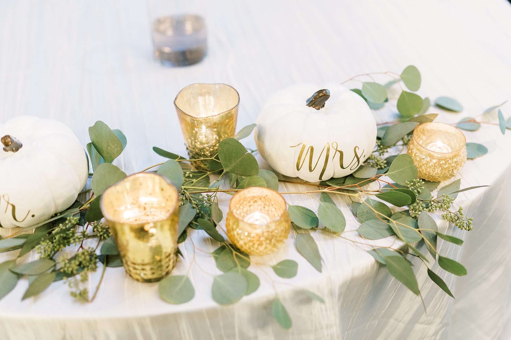 sweetheart table decor with pumpkins and gold candles