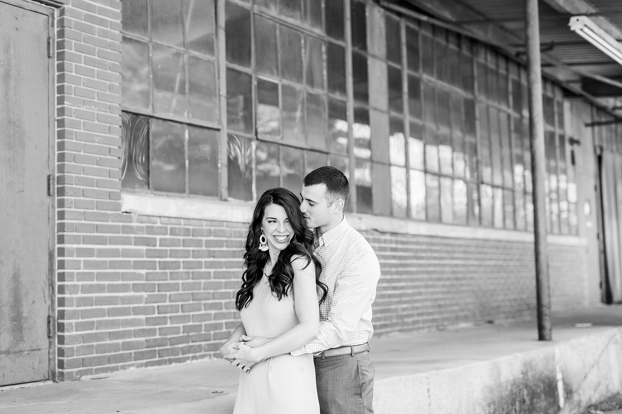 bride and groom pose by warehouse in Charlotte NC