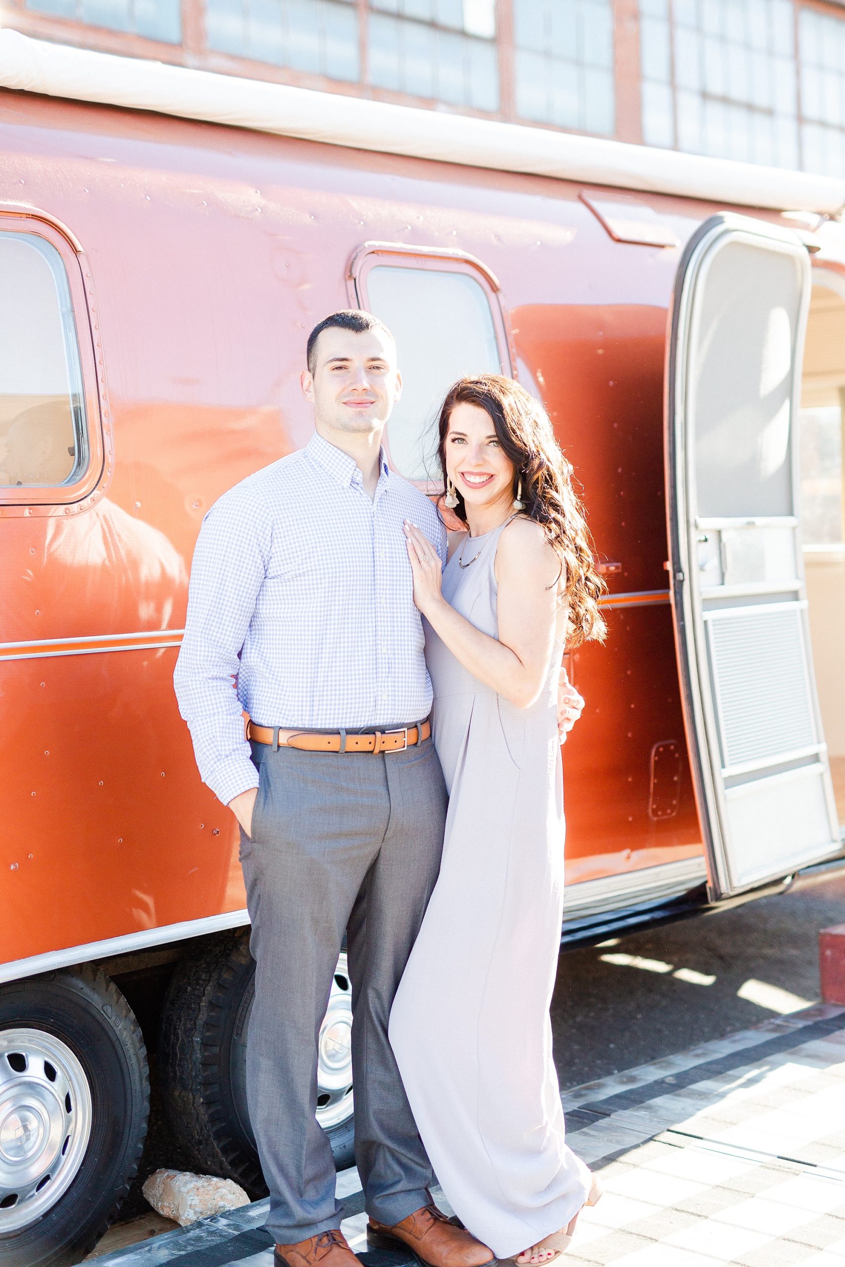 bride and groom pose by Airstream