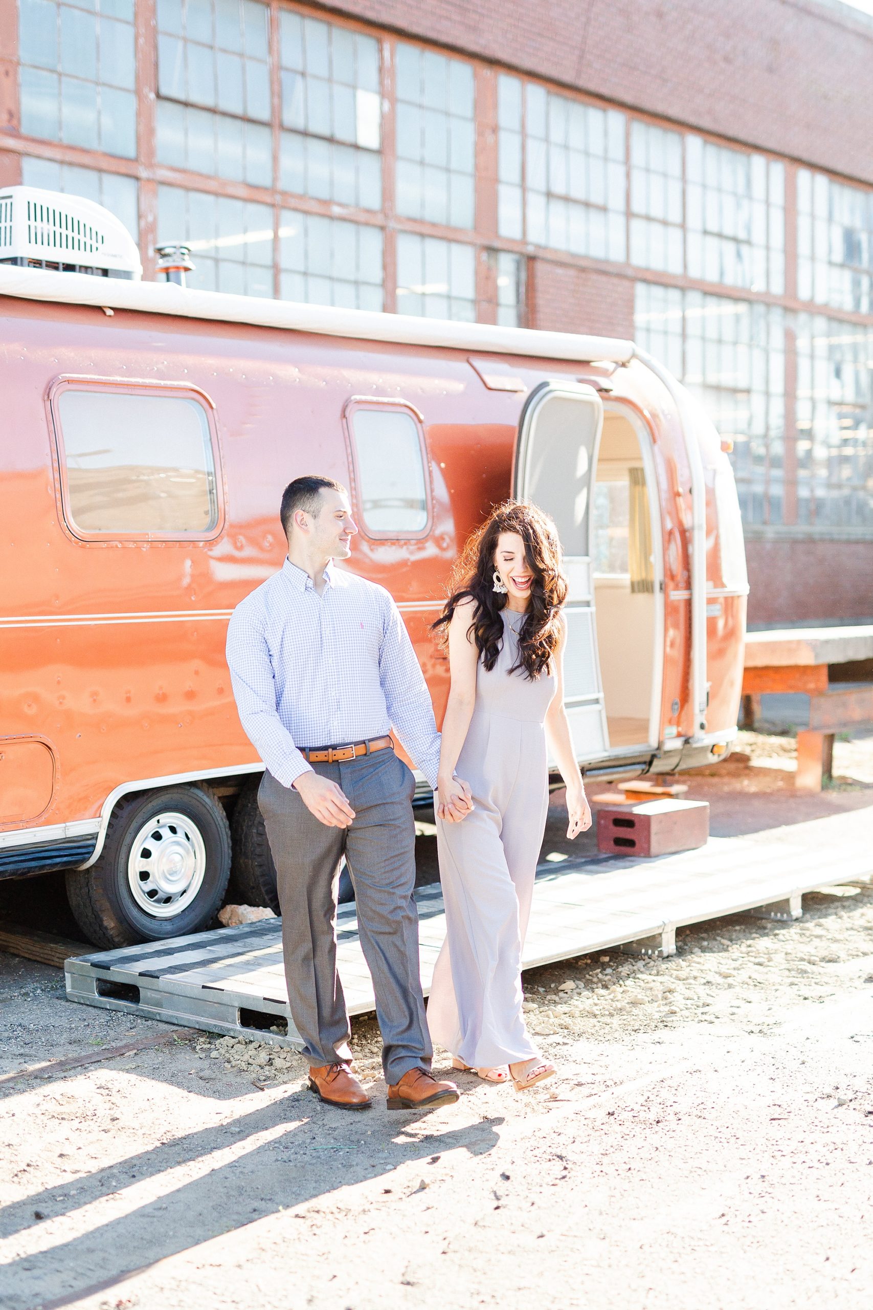 engaged couple poses by airstream in Charlotte NC