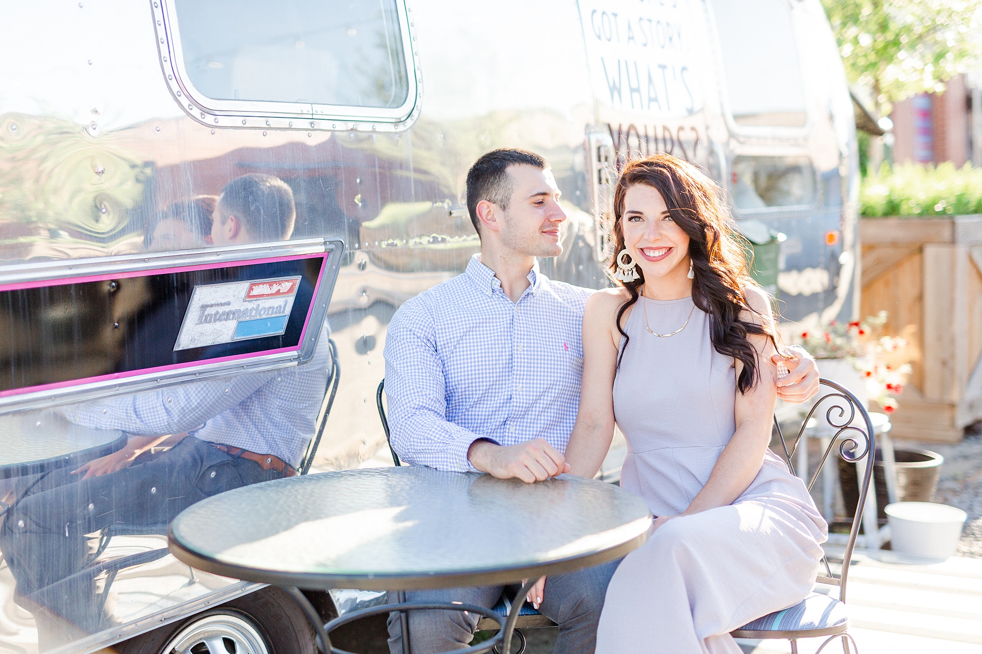 engaged couple poses during Camp North End engagement photos by airstream
