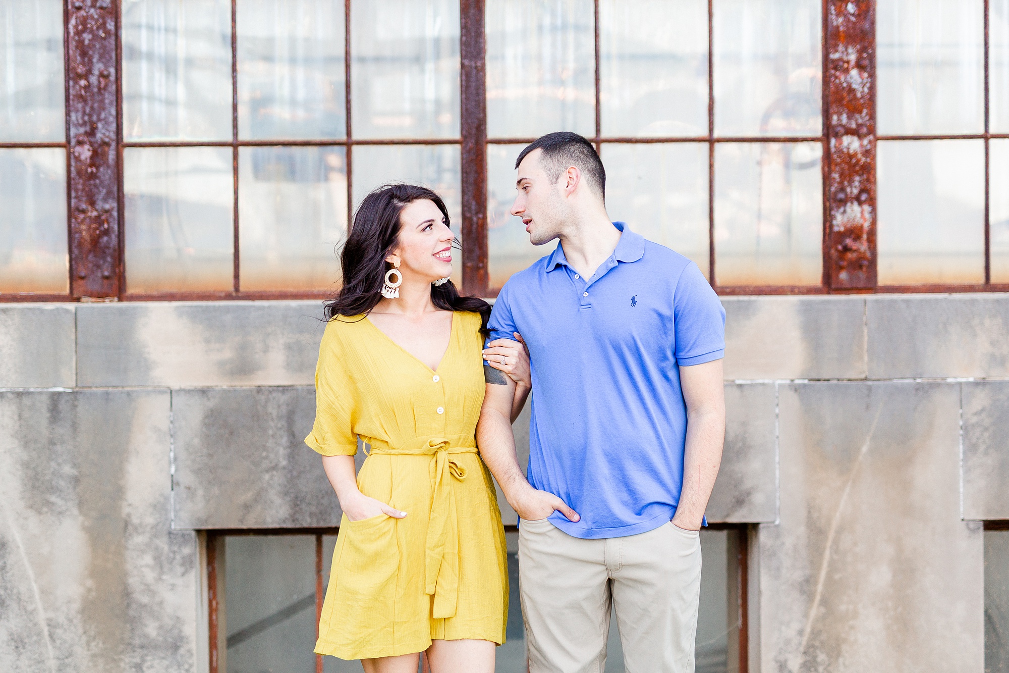 bride and groom in bright outfits pose outside historic warehouse