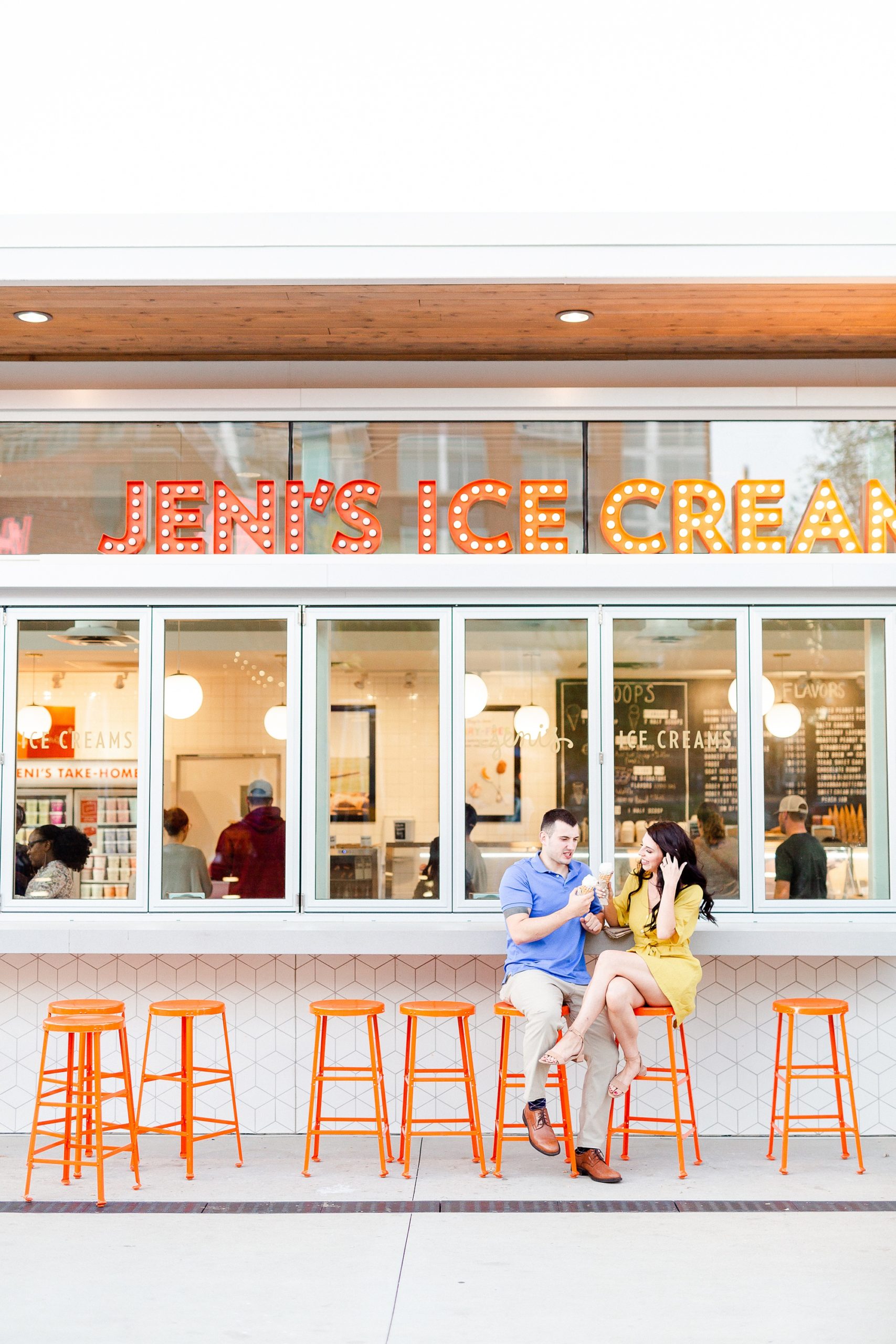 engaged couple poses outside Jeni's Ice Creams